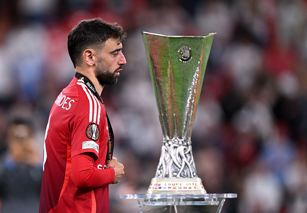 United captain Bruno Fernandes walks past the Europa League trophy after his team’s defeat