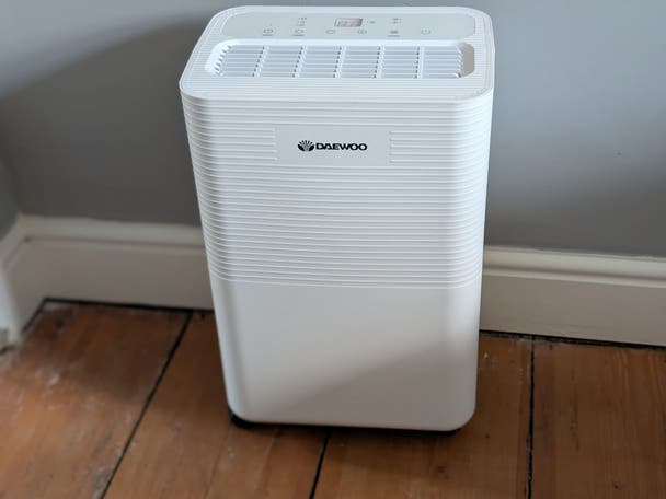 A Daewoo 16l dehumidifier on a wood floor in a dining room