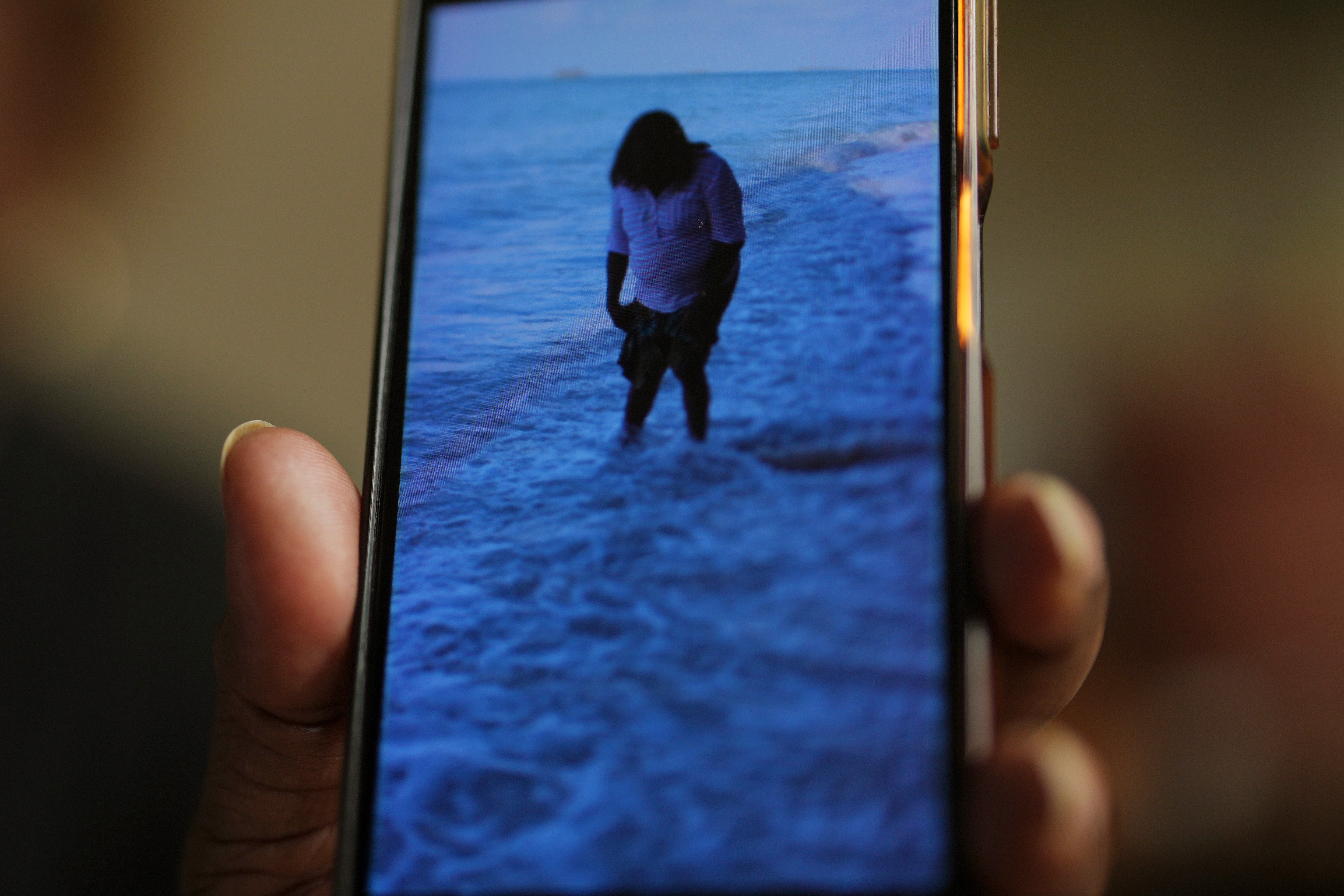 Chagossian Bernadette Dugasse shows photos of the Chagos Islands during an interview with The Associated Press, at her home in London, Tuesday, March 25, 2025. (AP Photo/Kin Cheung)