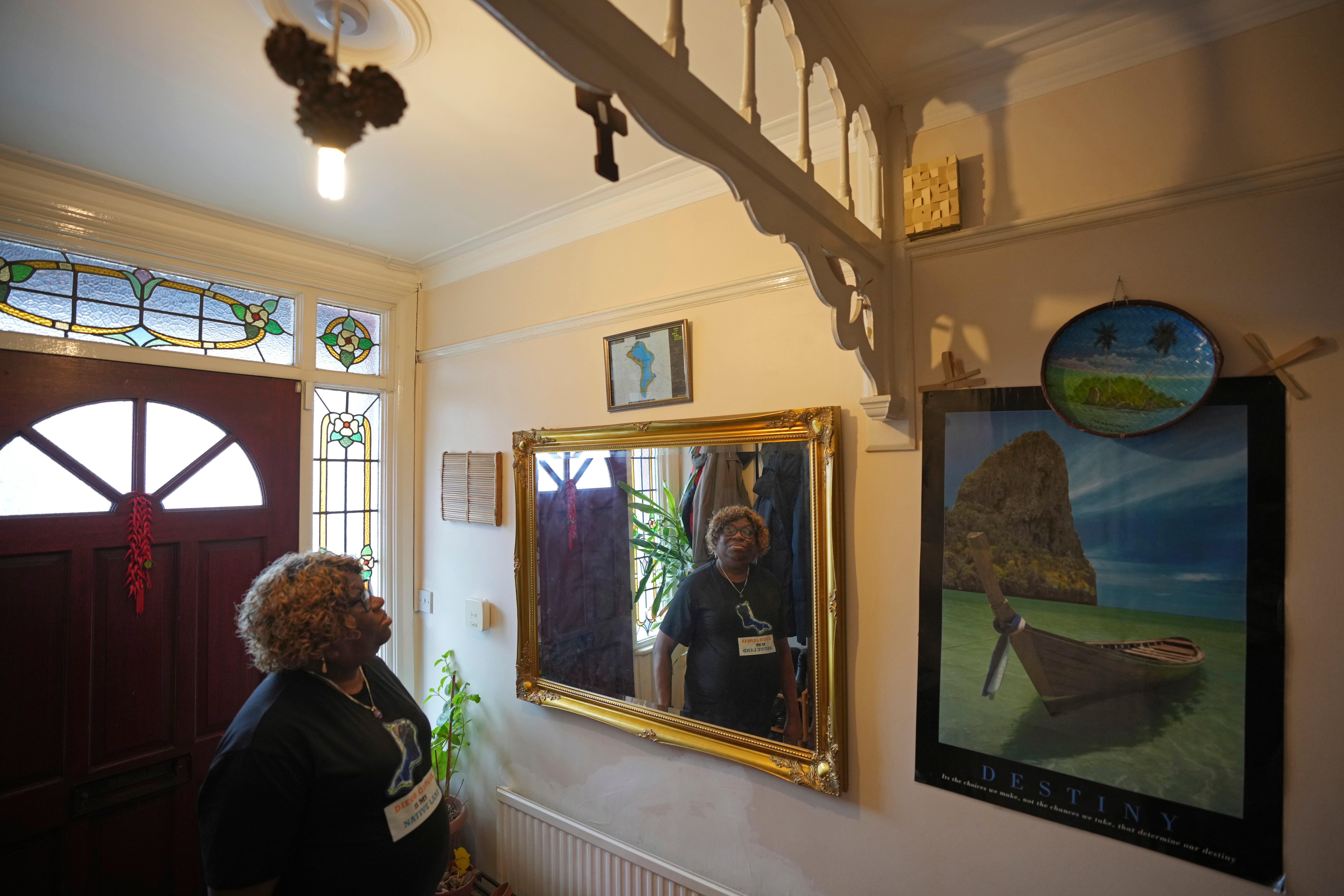 Chagossian Bernadette Dugasse looks at a Chagos Islands map during an interview with The Associated Press, at her home in London, Tuesday, March 25, 2025. (AP Photo/Kin Cheung)