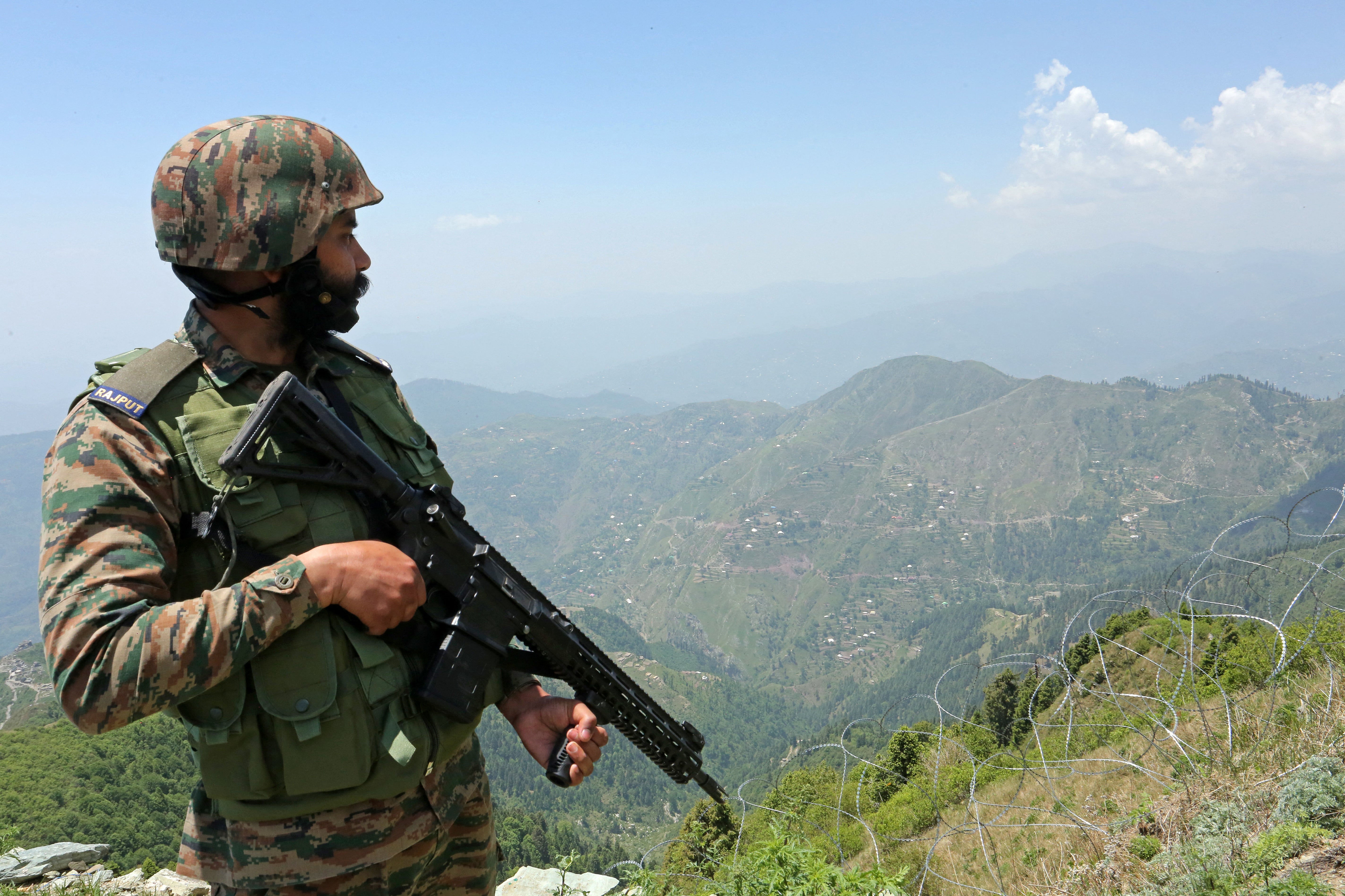 An Indian army soldier stands guard at the Line of Control (LoC) between Pakistan and India, in Poonch sector of India's Jammu region