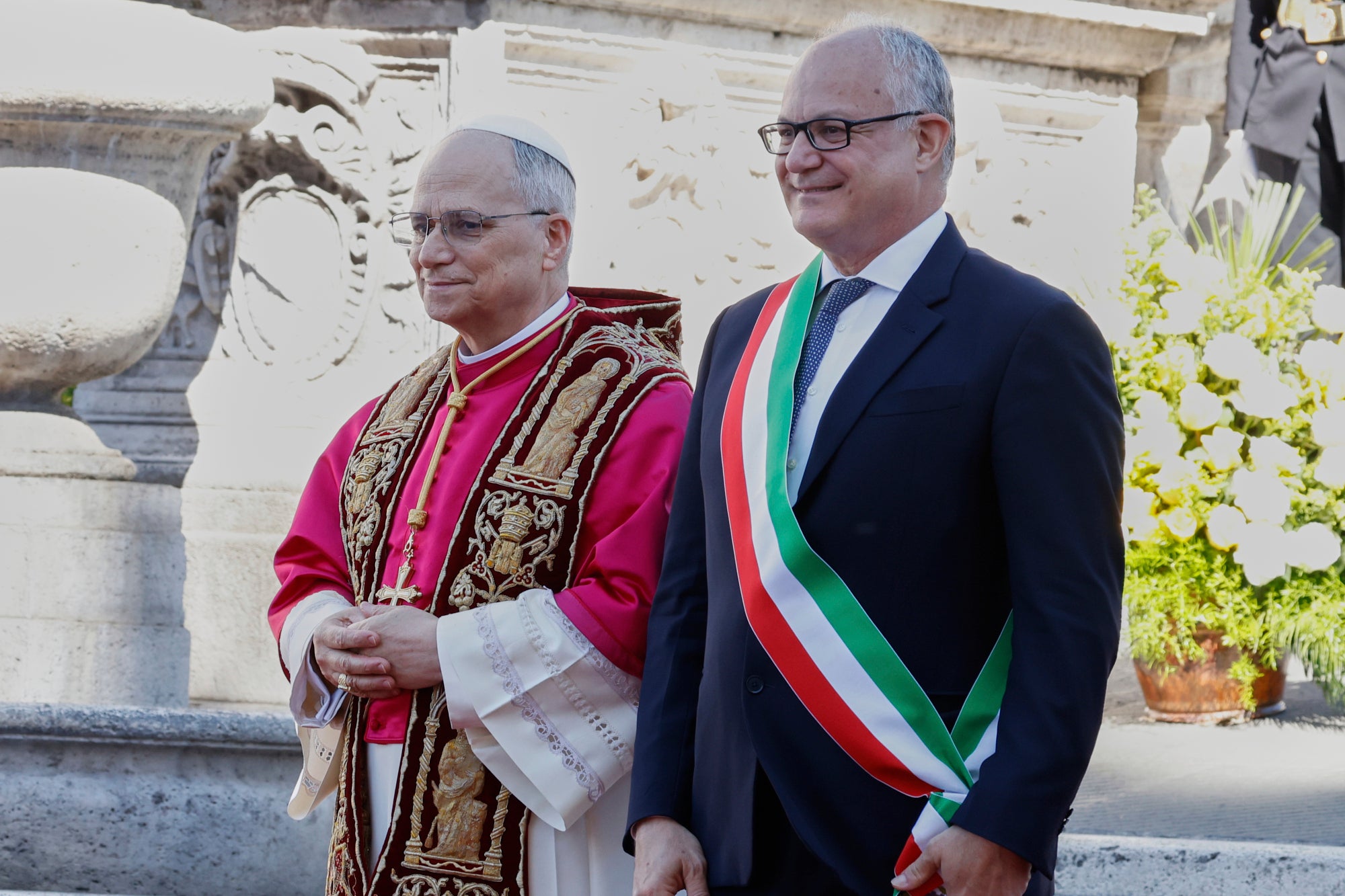 Pope Leo XIV is greeted by Rome's Mayor Roberto Gualtieri at the foot of Capitoline Hill, a symbolic gesture underscoring the pontiff's role as Bishop of Rome and his civic bond with the city, in Rome, Sunday, May 25, 2025. (AP Photo/Riccardo De Luca)
