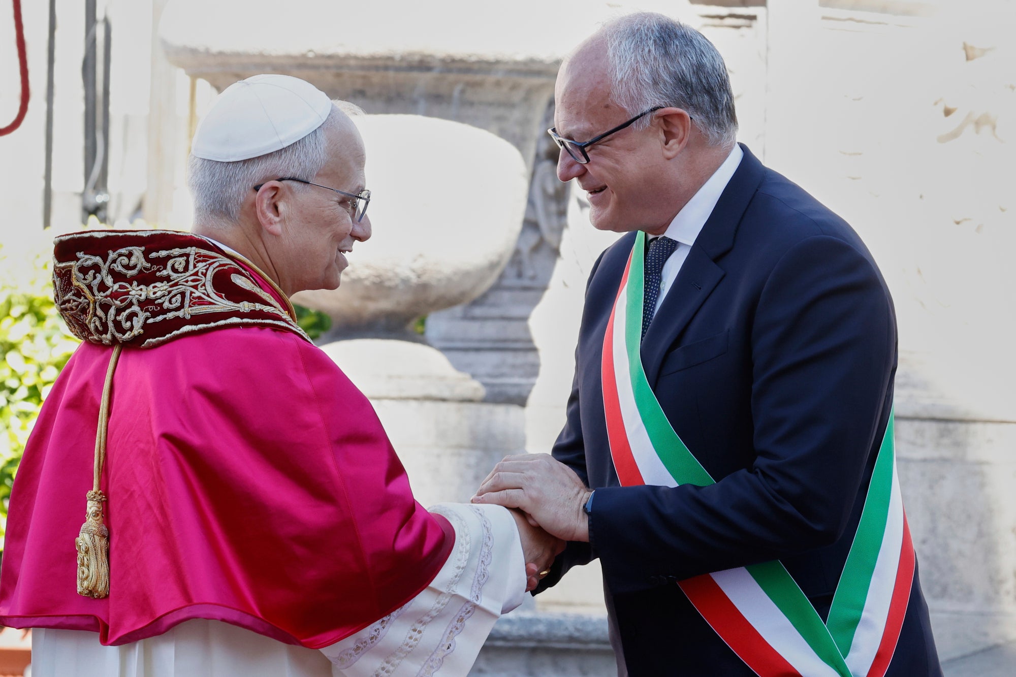Pope Leo XIV is greeted by Rome's Mayor Roberto Gualtieri at the foot of Capitoline Hill, a symbolic gesture underscoring the pontiff's role as Bishop of Rome and his civic bond with the city, in Rome, Sunday, May 25, 2025. (AP Photo/Riccardo De Luca)