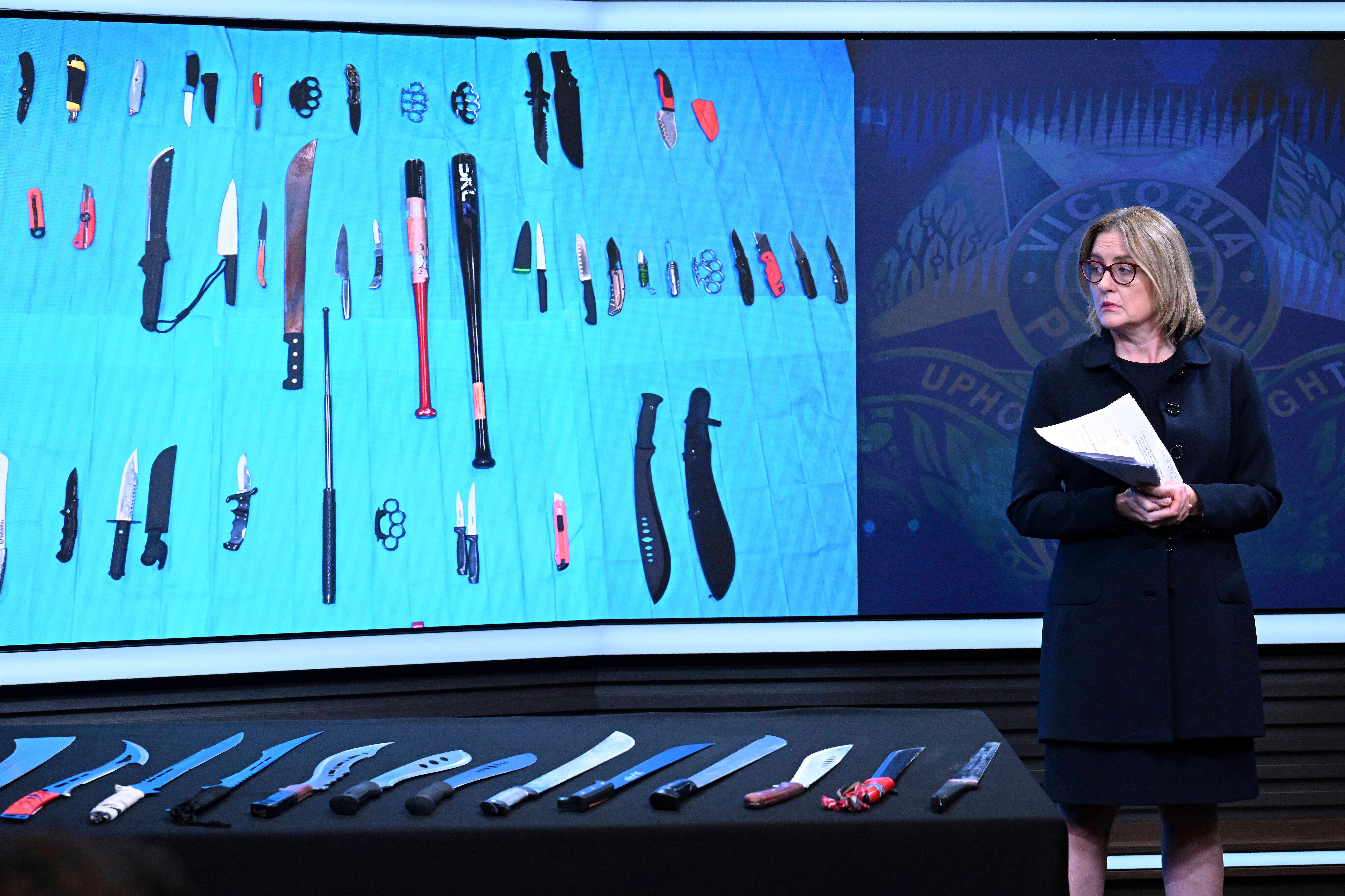 Victorian state Premier Jacinta Allan looks at a display of machetes during an announcement at Victoria Police Headquarters in Melbourne, Australia, Thursday, March 13, 2025. (James Ross/AAP Image via AP)