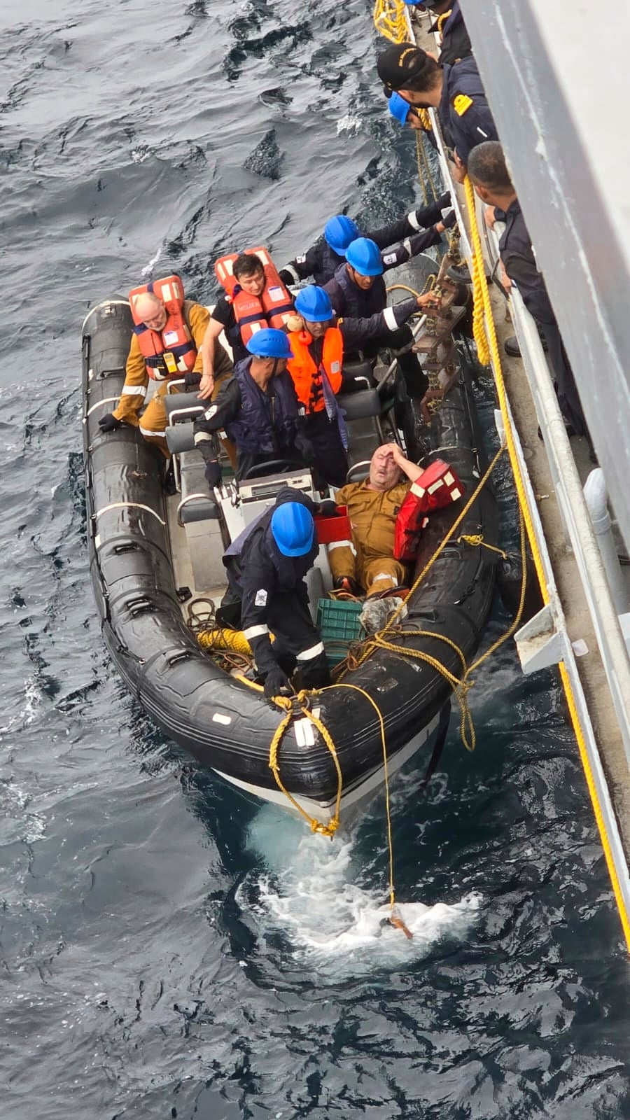 Coast guard members rescue crew members of the Liberia-flagged MSC ELSA 3, a container ship carrying hazardous cargo after it sank off Indian southern coast in the Arabian Sea Sunday
