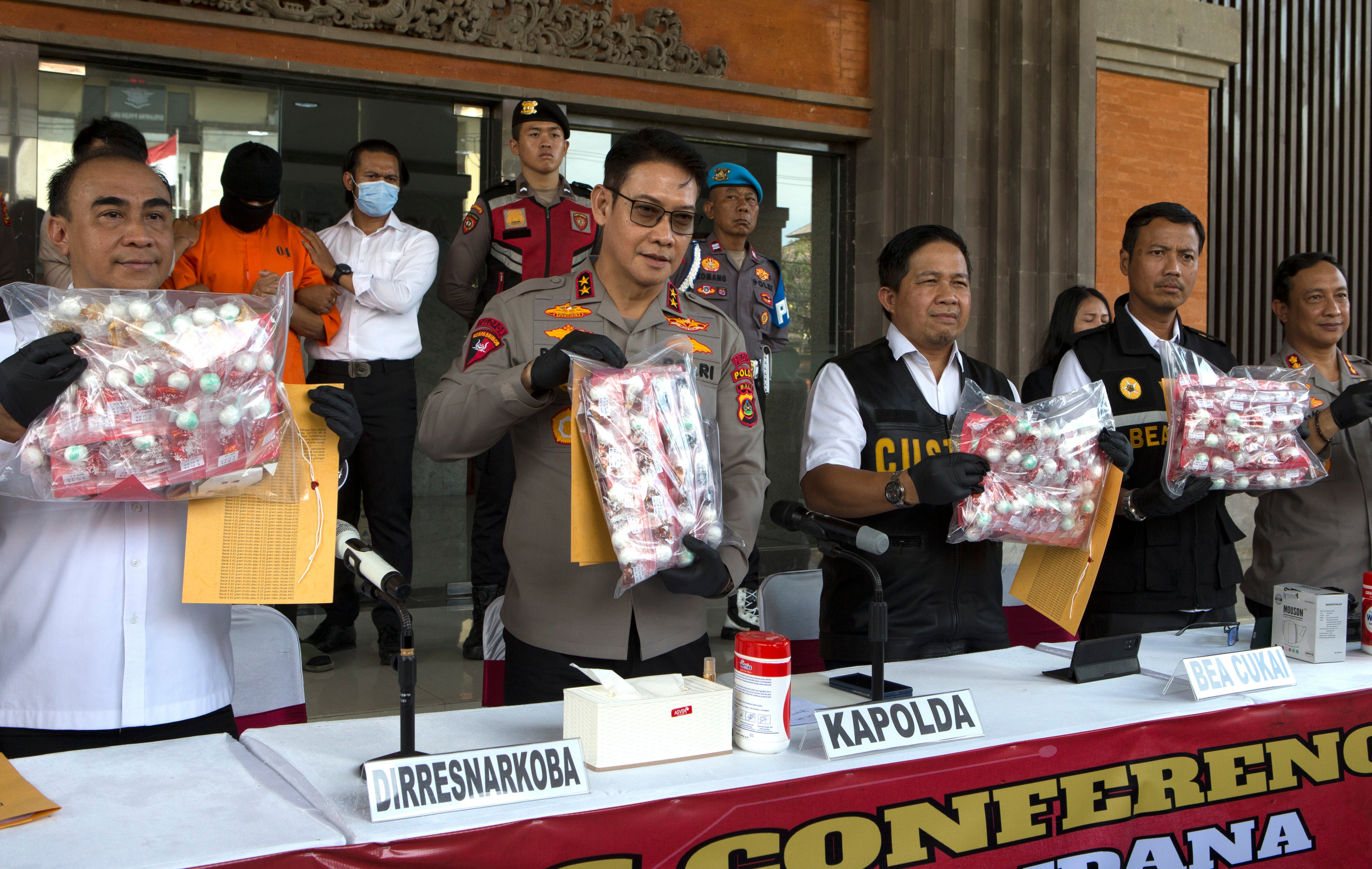 Authorities hold a news conference as an Australian man, second left in the background, arrested for allegedly smuggling cocaine stands at the police headquarters in Bali, Indonesia, Monday, May 26, 2025. (AP Photo/Firdia Lisnawati)