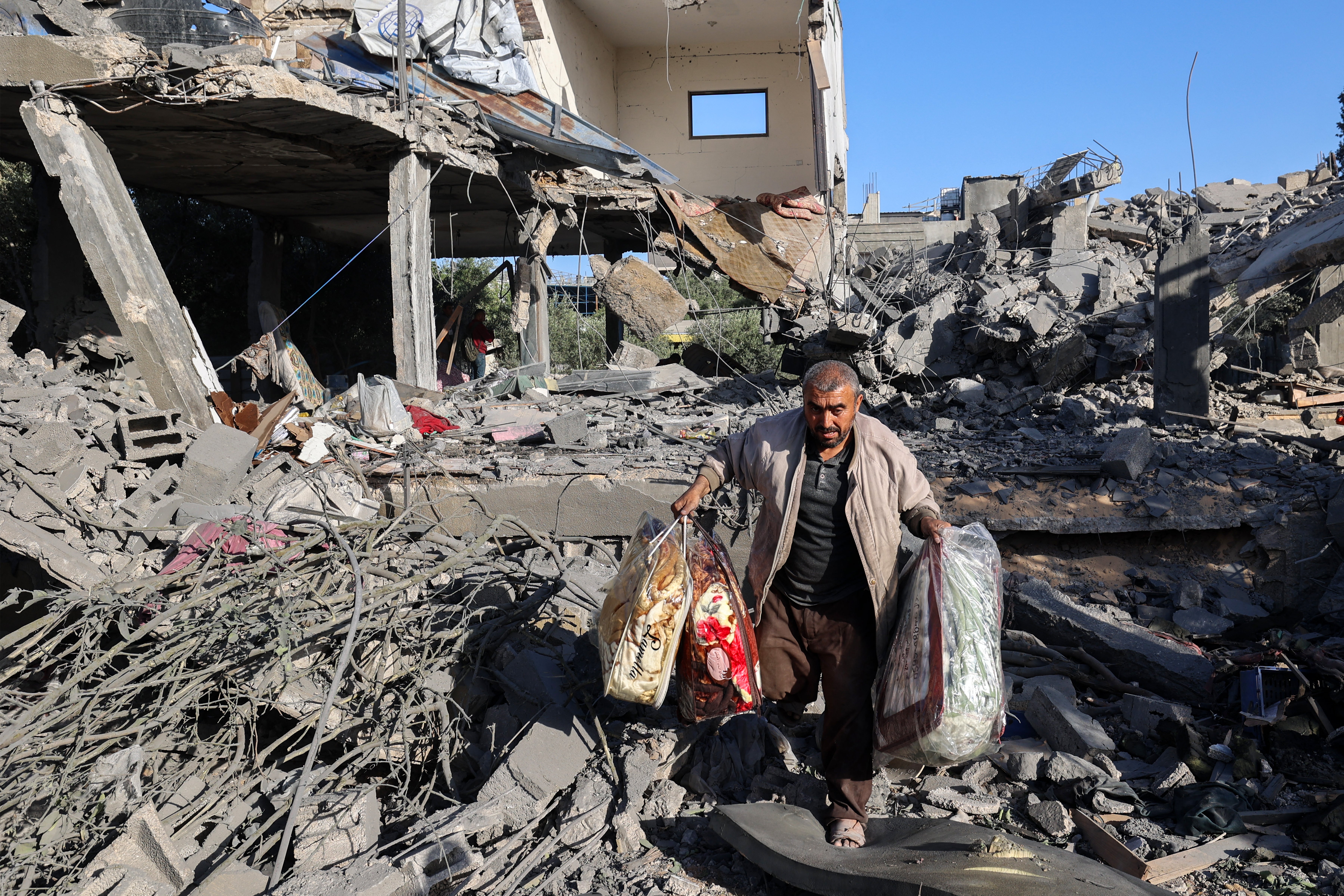 A Palestinian man salvages his belongings from a house targeted by Israeli forces in the Nuseirat refugee camp in Gaza