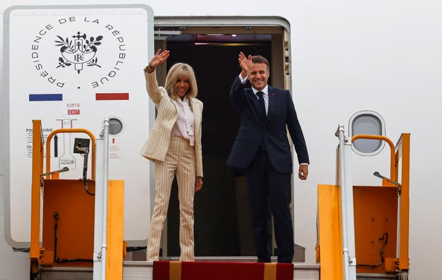 <p>France's President Emmanuel Macron and his wife Brigitte Macron wave as they board their plane for departure following their visit to Vietnam at Noi Bai International Airport in Hanoi</p>