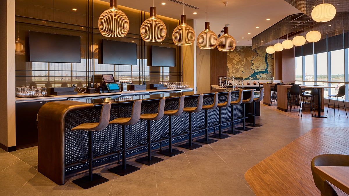 The new lounges 'feel less like an airport and more like a modern hospitality destination'. Above is the Admirals Club bar