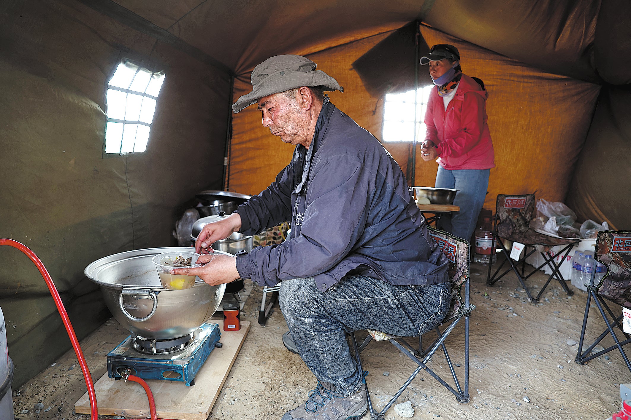 Team members cook in their campsite in the desert