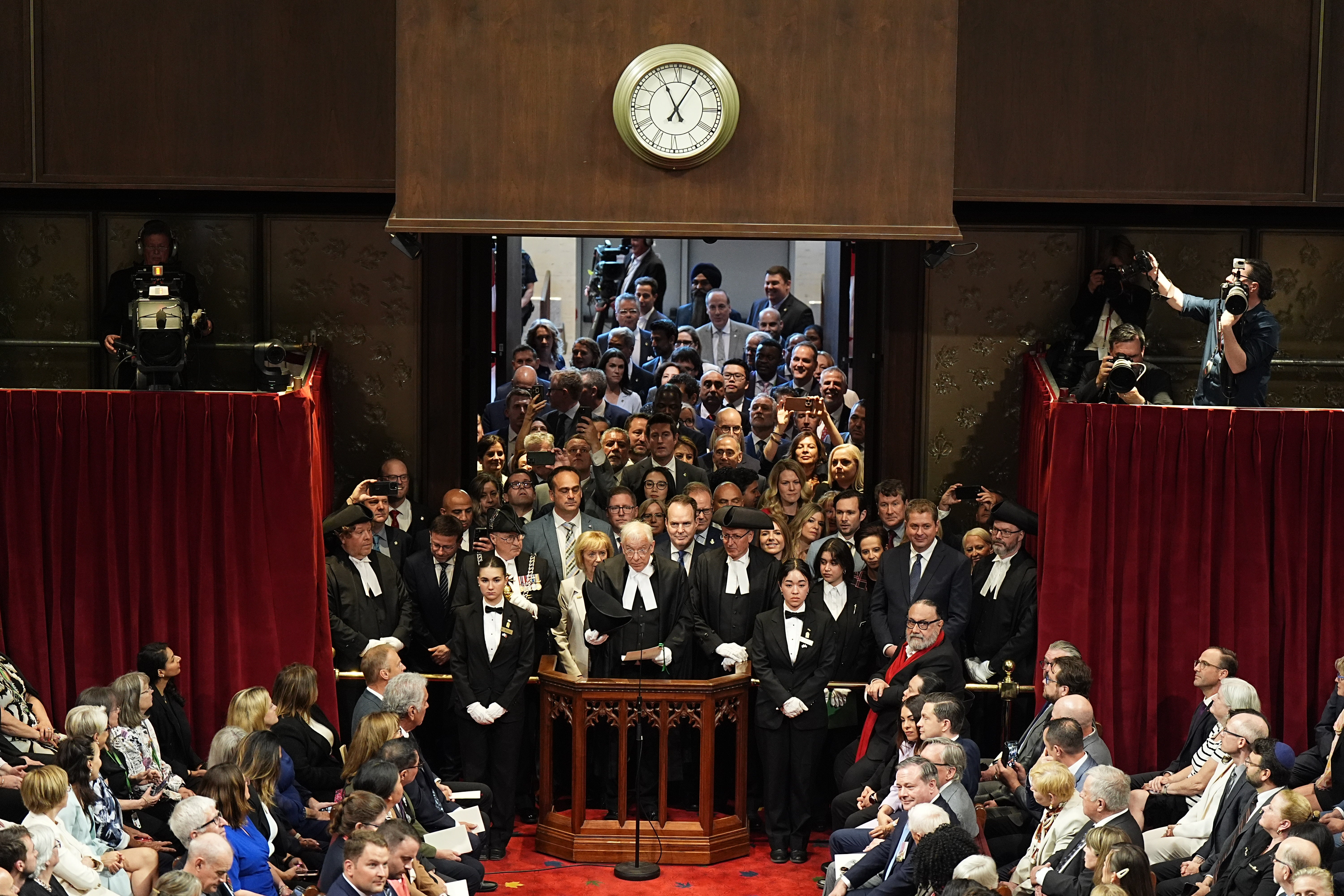 Members of the House of Commons gather in the doorway to listen to Charles