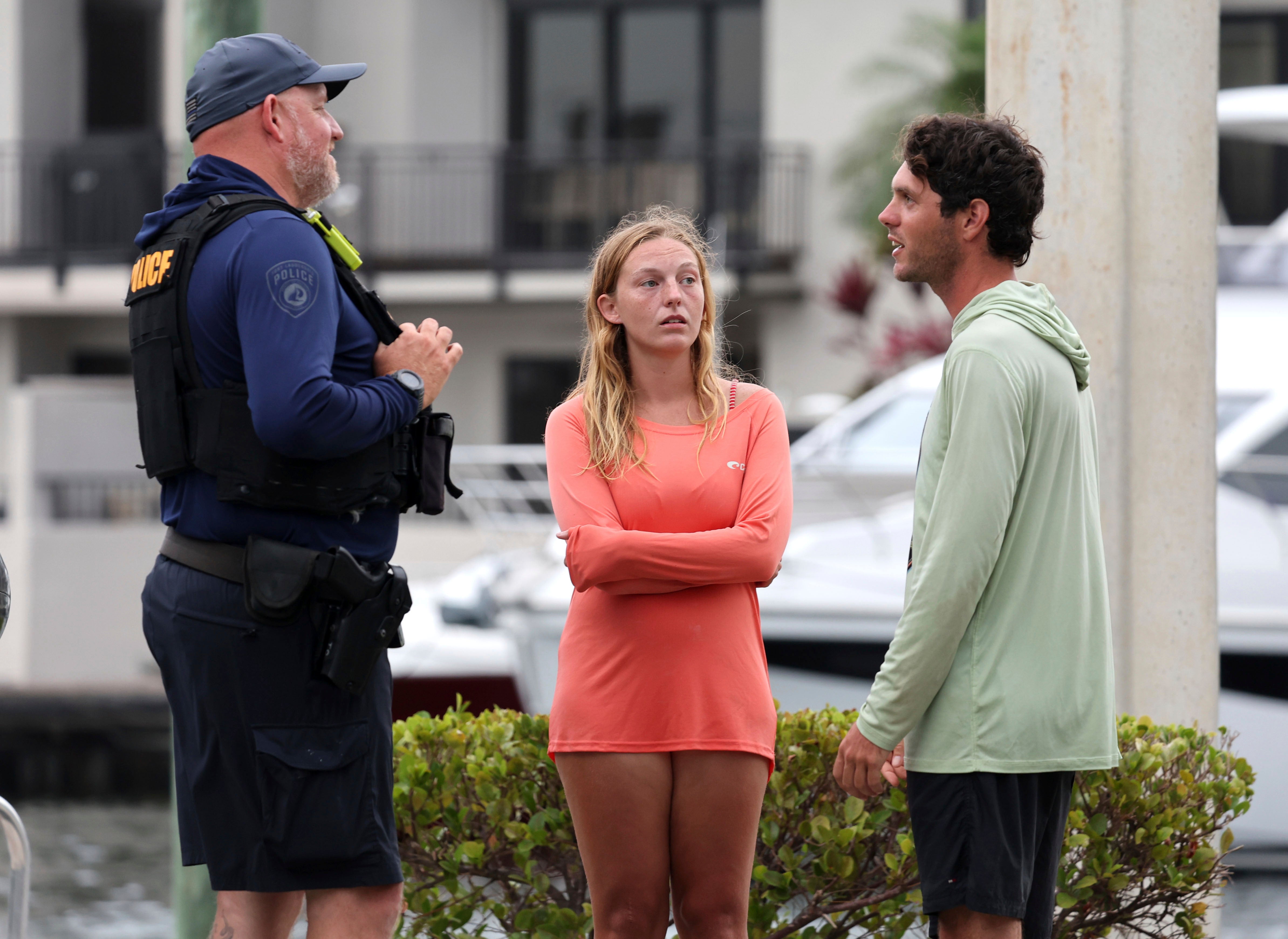 Marisa Toomsen and Bret Triano talk to a Fort Lauderdale police after helping rescue those injured in the boat explosion