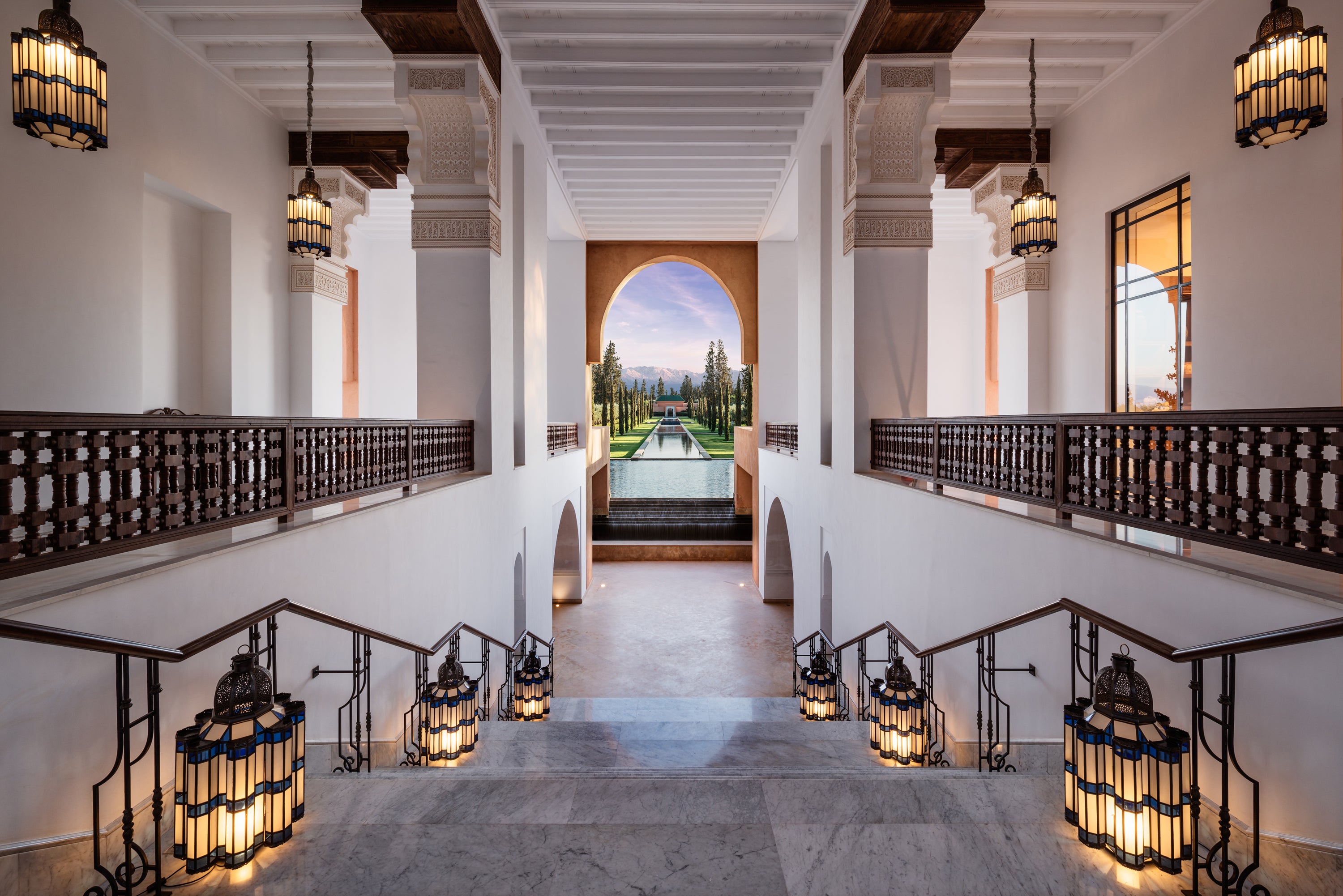 The palatial main building looks down along the hotel's 'grand canal', framing the Atlas Mountains in the distance