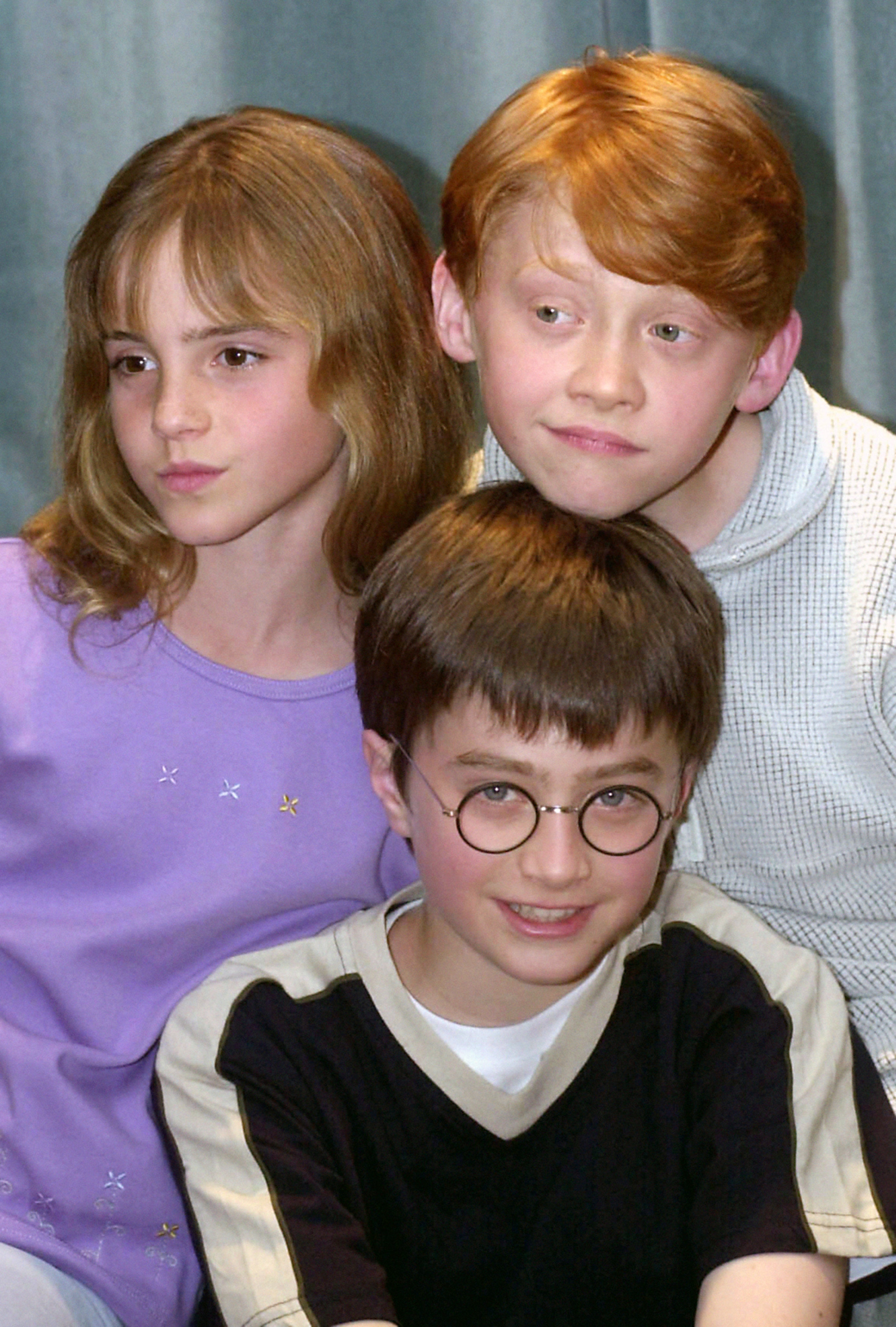 Daniel Radcliffe (centro) com seus colegas de elenco Emma Watson (esquerda) e Rupert Grint (direita) quando foram escalados para os filmes de Harry Potter, há mais de duas décadas.