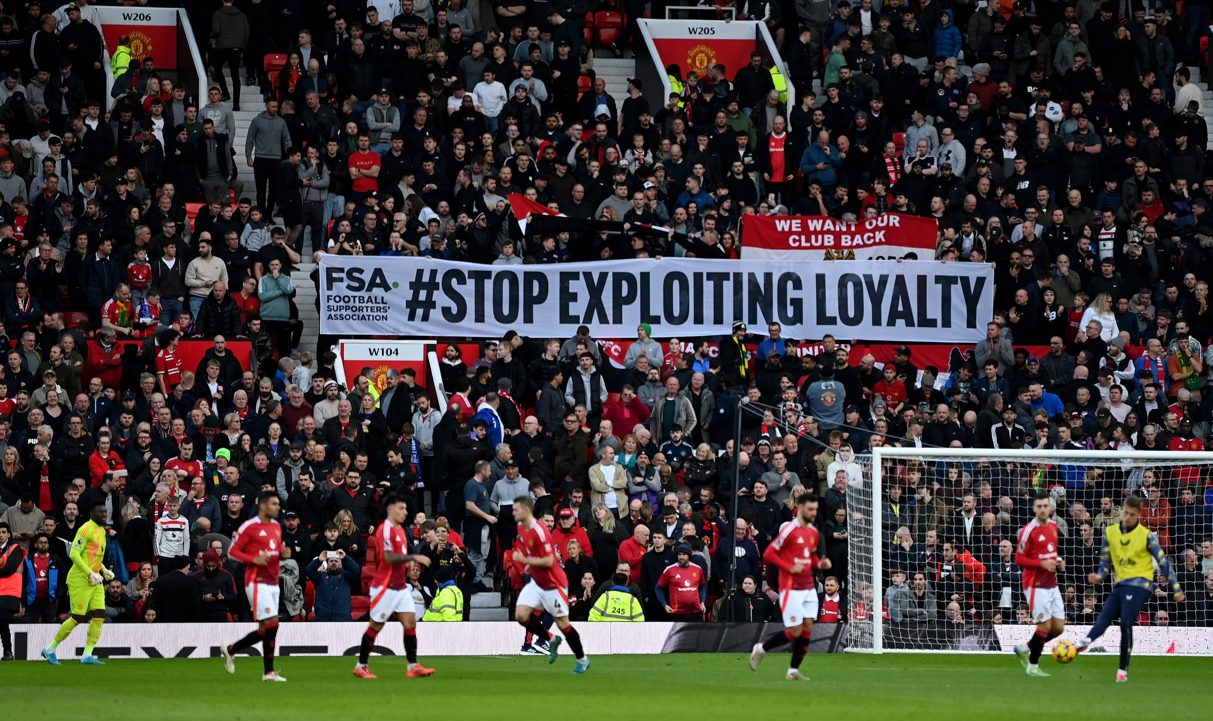 Fans of Manchester United are seen with a #Stop Exploiting Loyalty banner in protest against ticket prices