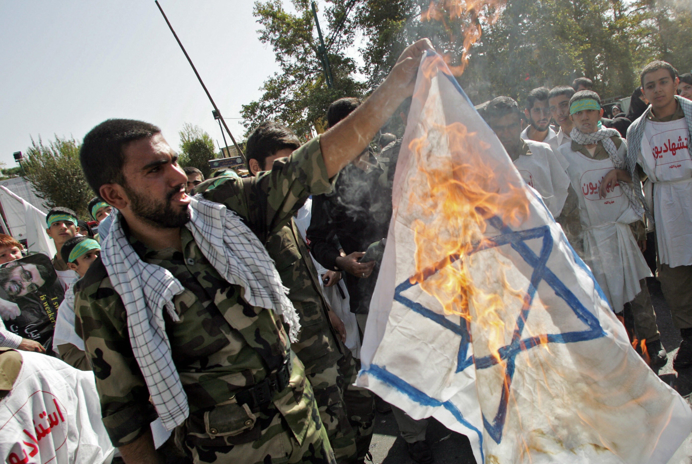 A member of Iran’s Revolutionary Guards burns an Israeli flag during a demonstration held in Tehran to mark Jerusalem (Al-Quds) Day