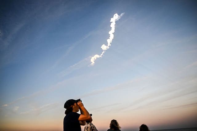 <p>People watch the launch of a SpaceX Falcon 9 rocket carrying 21 second-generation Starlink satellites from Space Launch Complex 40 at Nasa's Kennedy Space Center, in Cocoa Beach, Florida, on 27 February, 2023</p>