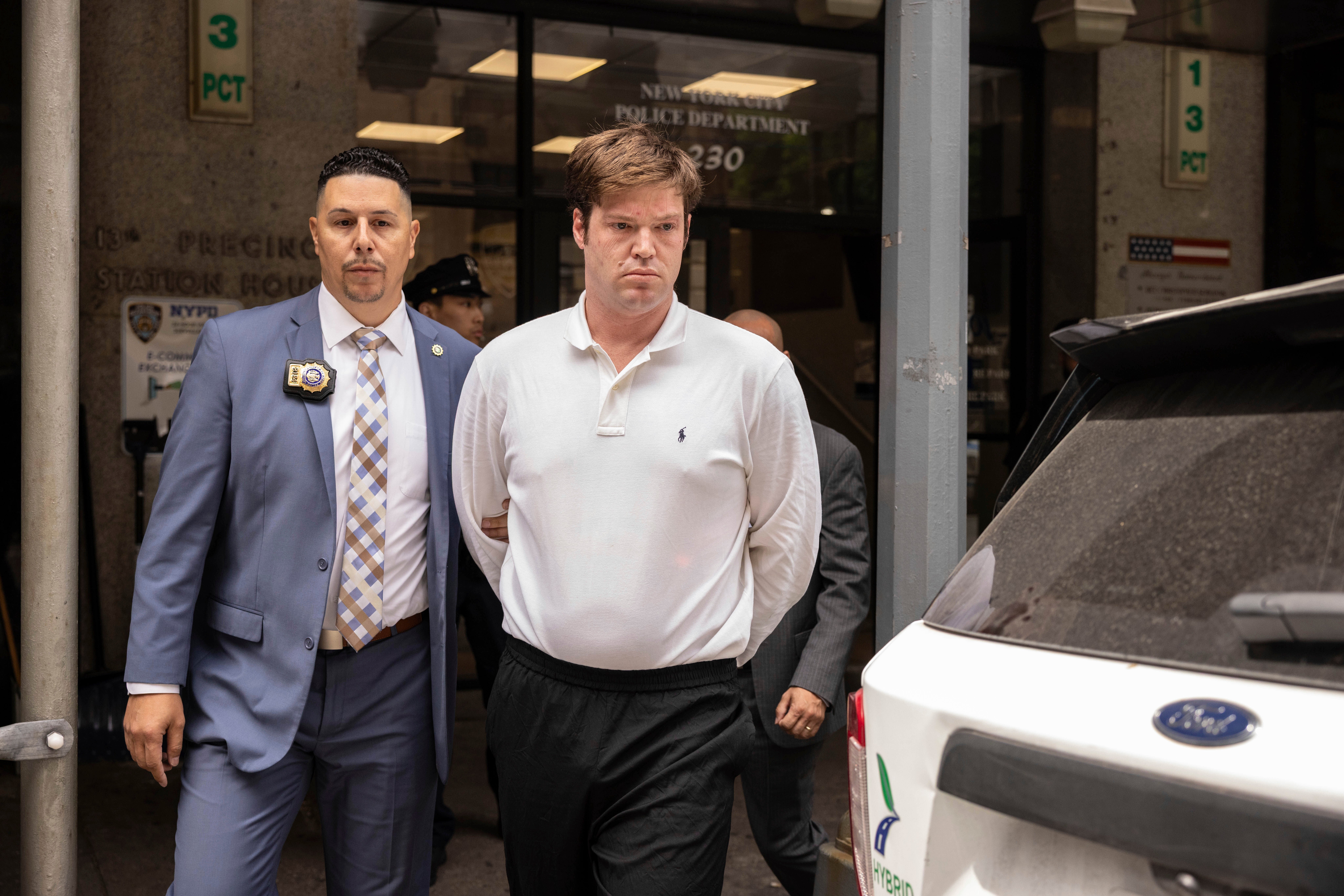 William Duplessie is escorted out of the New York Police 13th Precinct after turning himself in on charges of kidnapping and false imprisonment, Tuesday, May 27, 2025, in New York. (AP Photo/Yuki Iwamura)