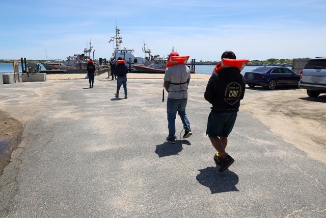 Detainees board a Coast Guard vessel as ICE conducts immigration enforcement operations on Nantucket