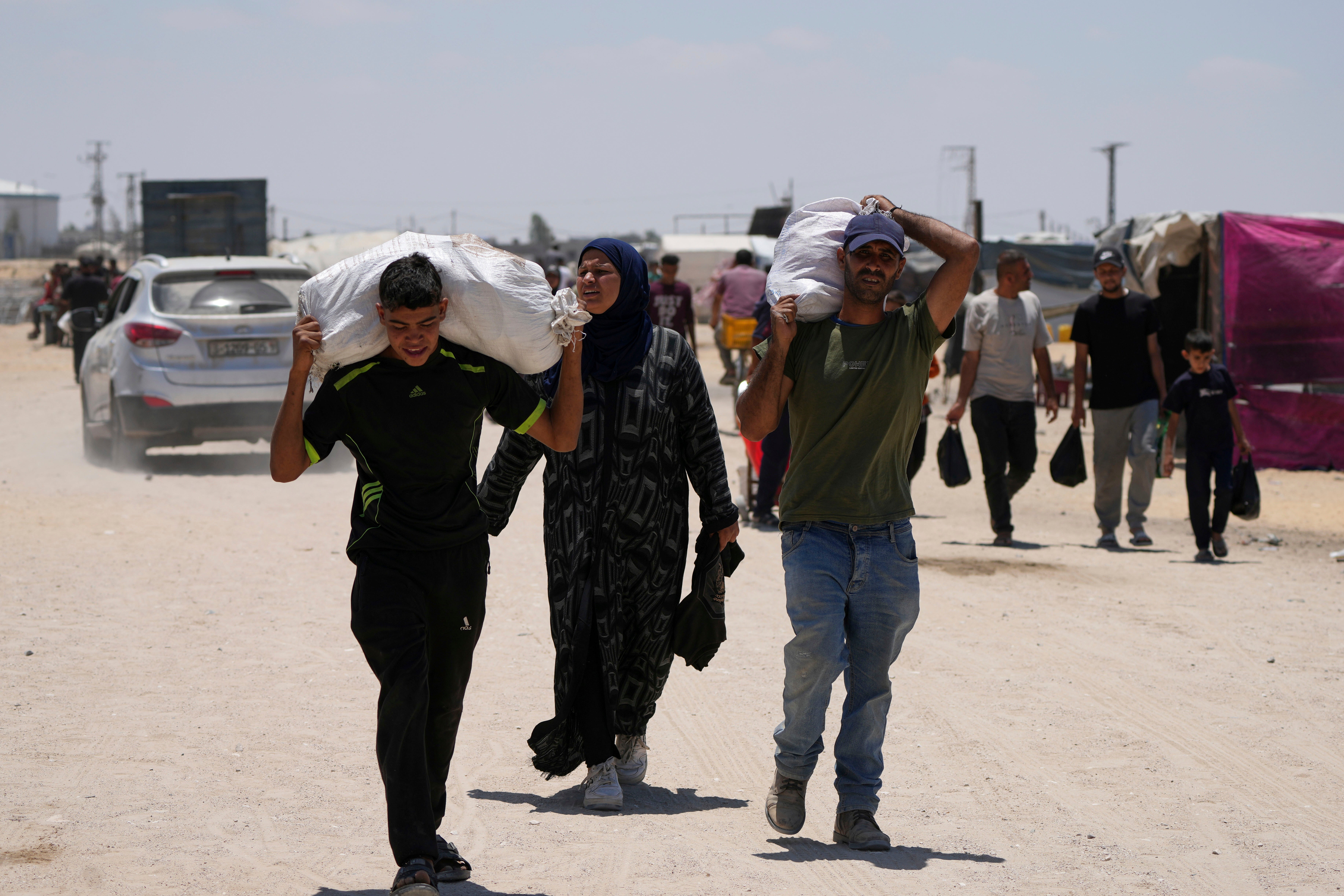 Palestinians carry food and humanitarian aid delivered by the Gaza Humanitarian Foundation, backed by the US, as they arrive in Khan Younis on 28 May 2025