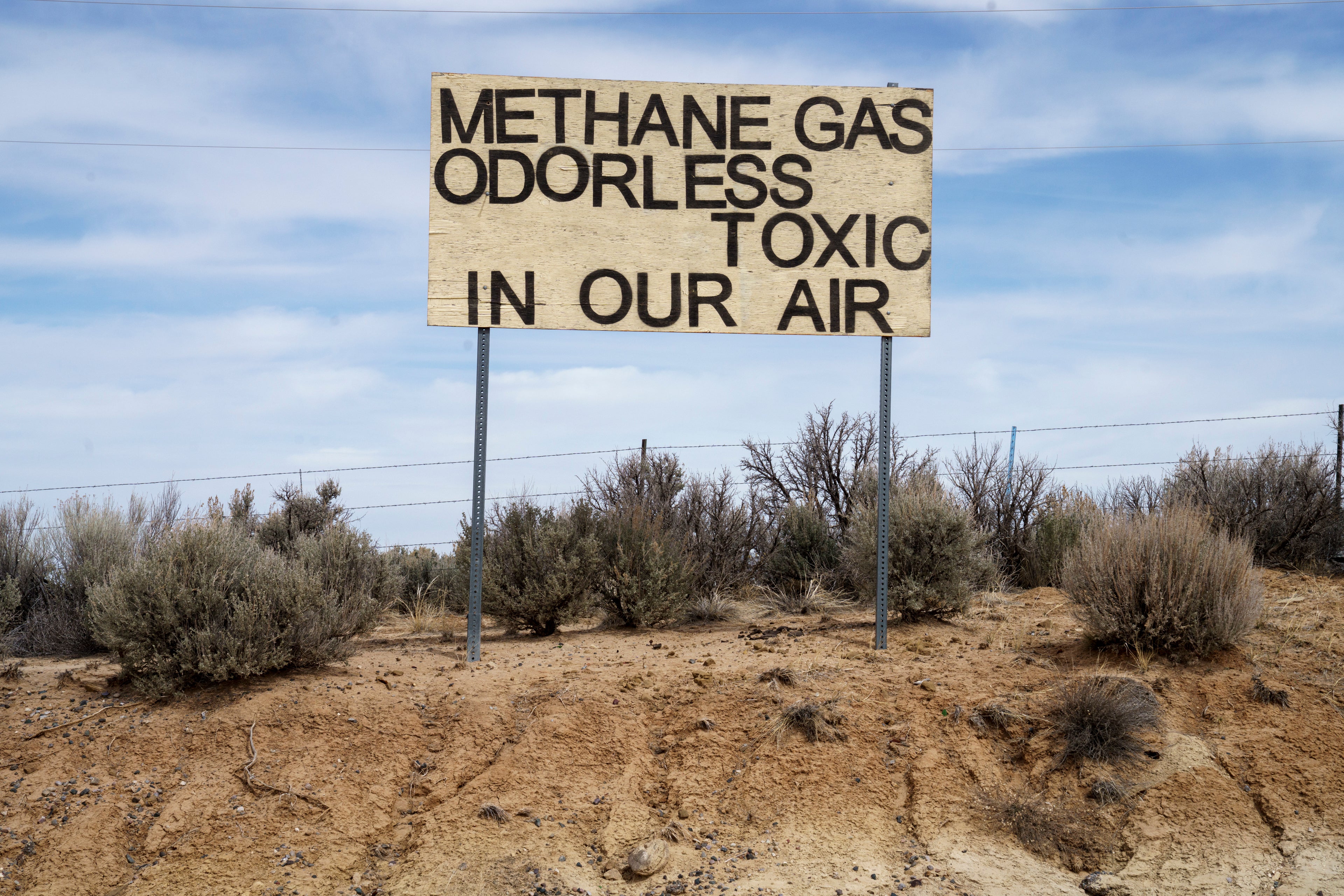 A sign protesting emissions from oil and gas stands across from Lybrook Elementary School, in Counselor, N.M., Navajo Nation