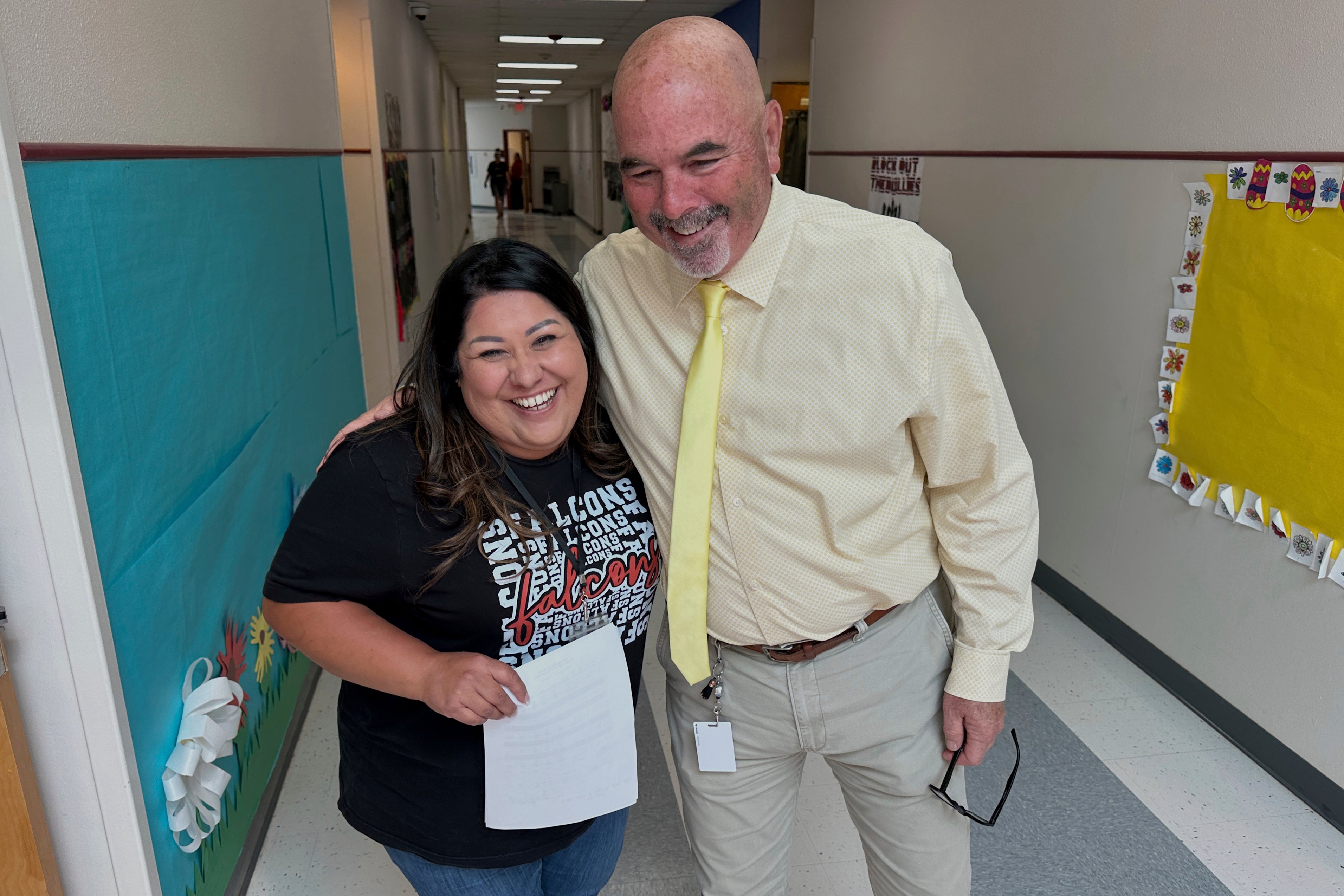 Superintendent Lee White shares a hug with teacher Vanessa Calderon in the hall of the elementary school in Loving, N.M., on Monday, May 19, 2025