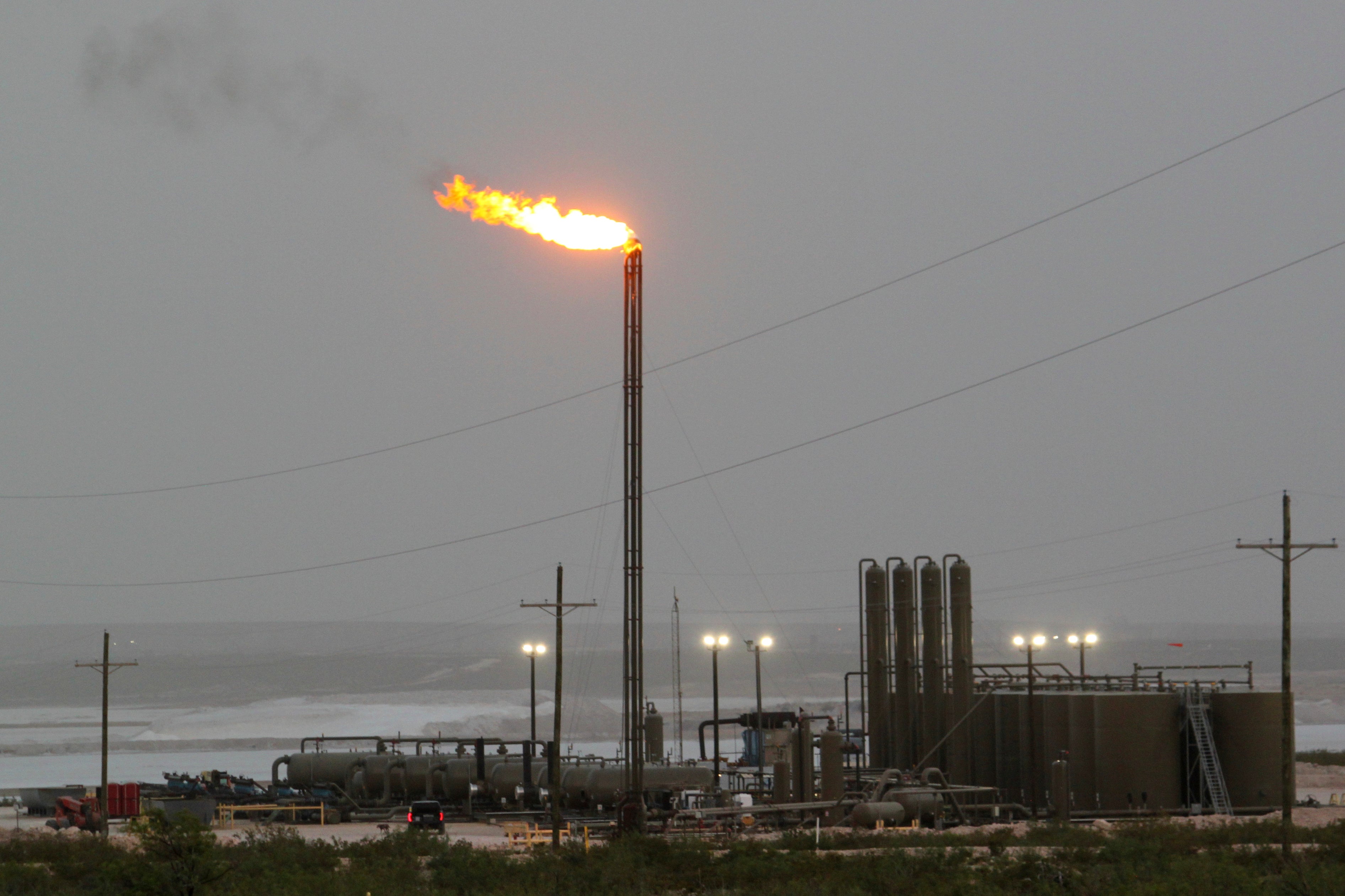 Strong winds kick up dust as a facility in the Permian Basin flares natural gas east of Carlsbad, N.M., on Monday, May 19, 2025