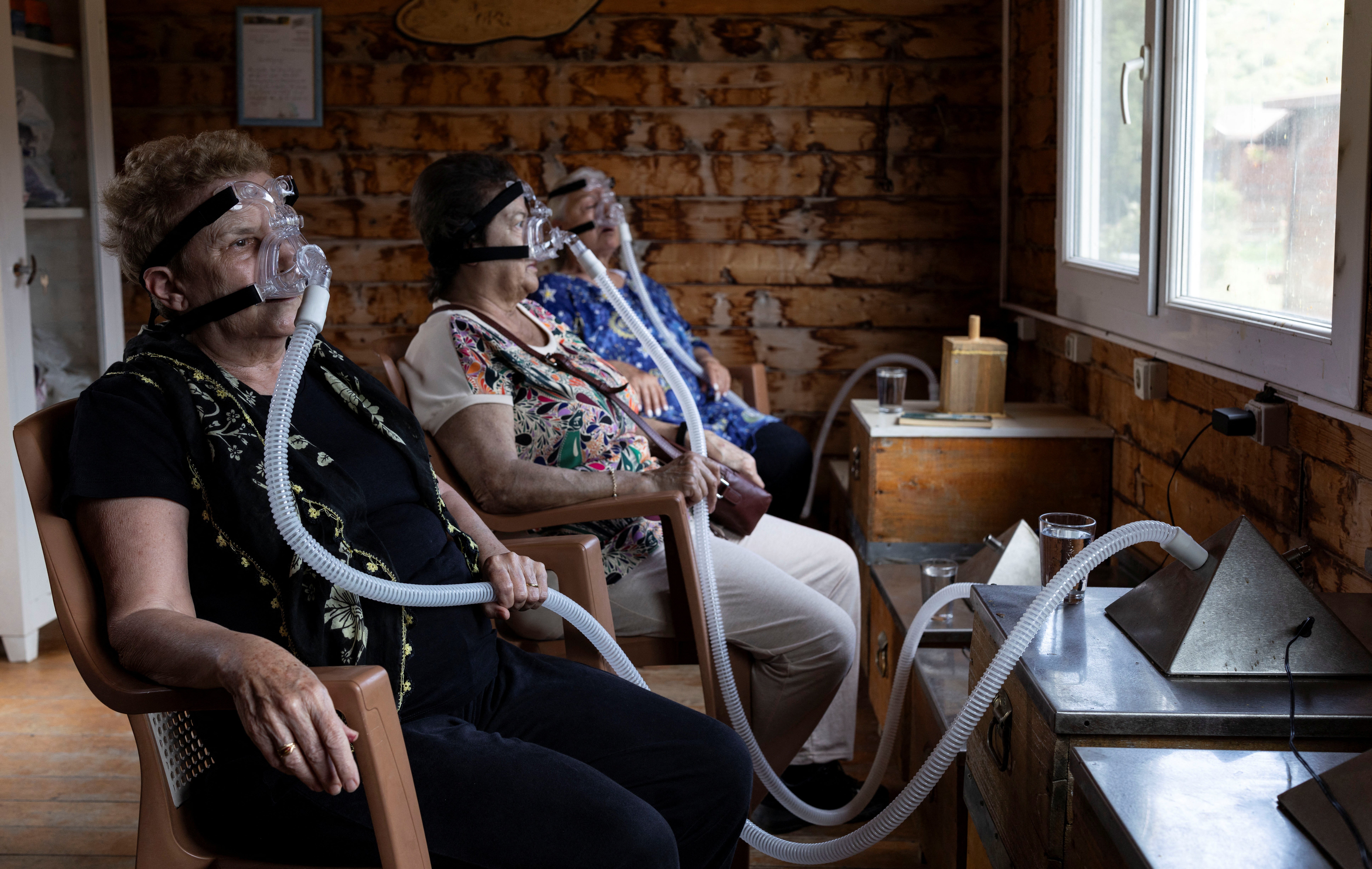 Senay Ilhan and Ulku Ozman breathe in air from beehives through ventilators