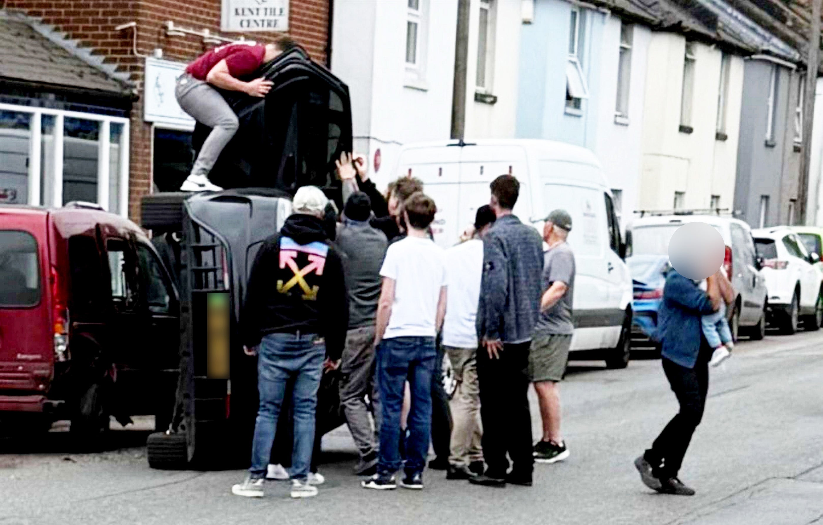 The moment a group of heroic youngsters jumped into action to pull a young couple and a baby from a car after it flipped onto its side