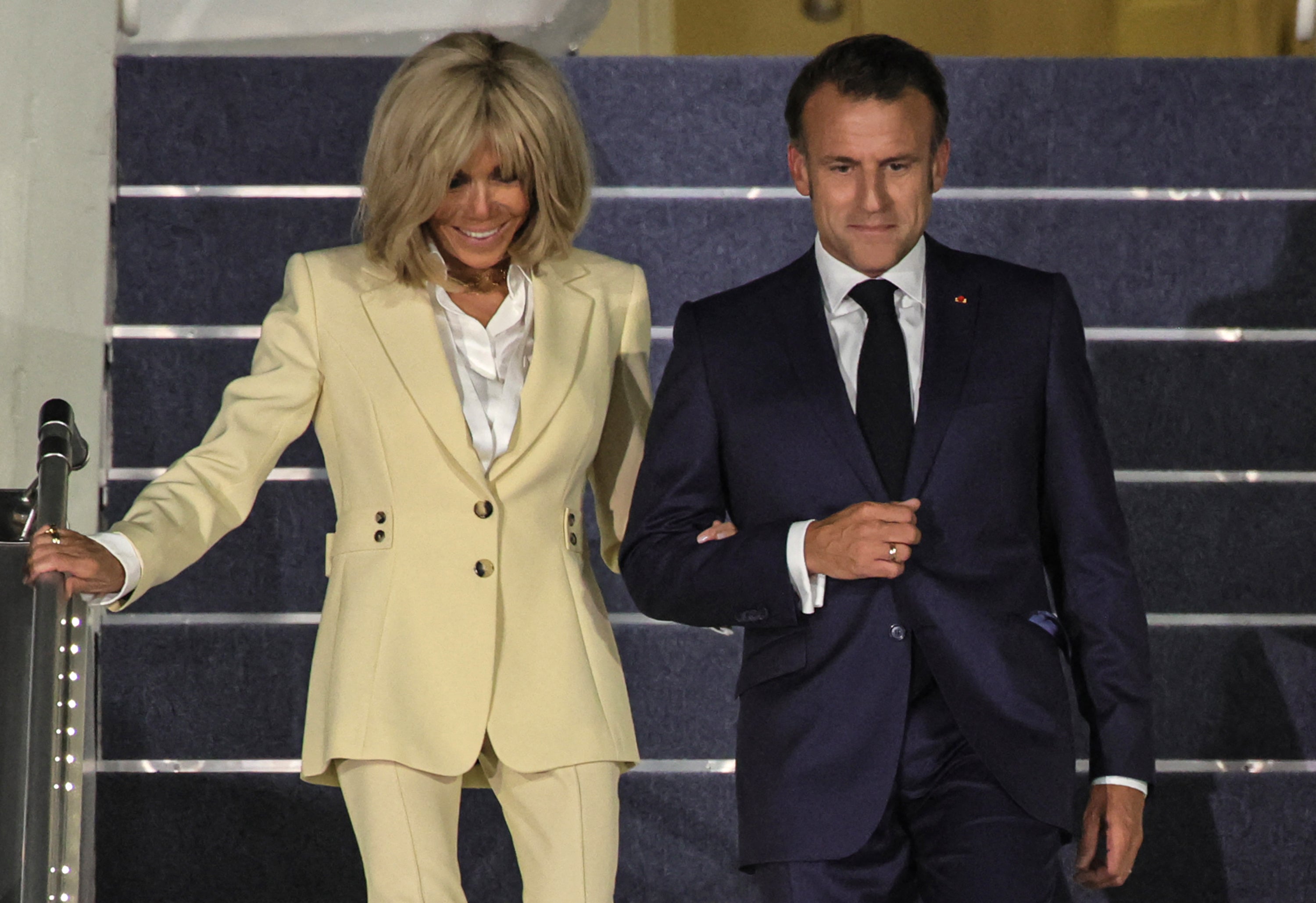 Emmanuel and Brigitte Macron were pictured smiling arm-in-arm as they walked down the steps of France’s presidential plane in Indonesia