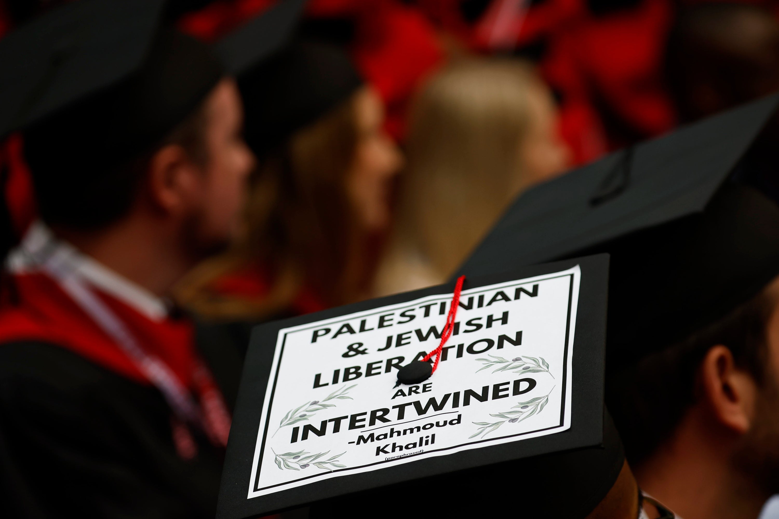 A Harvard University graduate student wears a placard reading ‘Palestinian & Jewish Liberation are Intertwined’ during graduation ceremonies on May 29 after the Trump administration pressured the college to crack down on pro-Palestine protests or risk federal funding