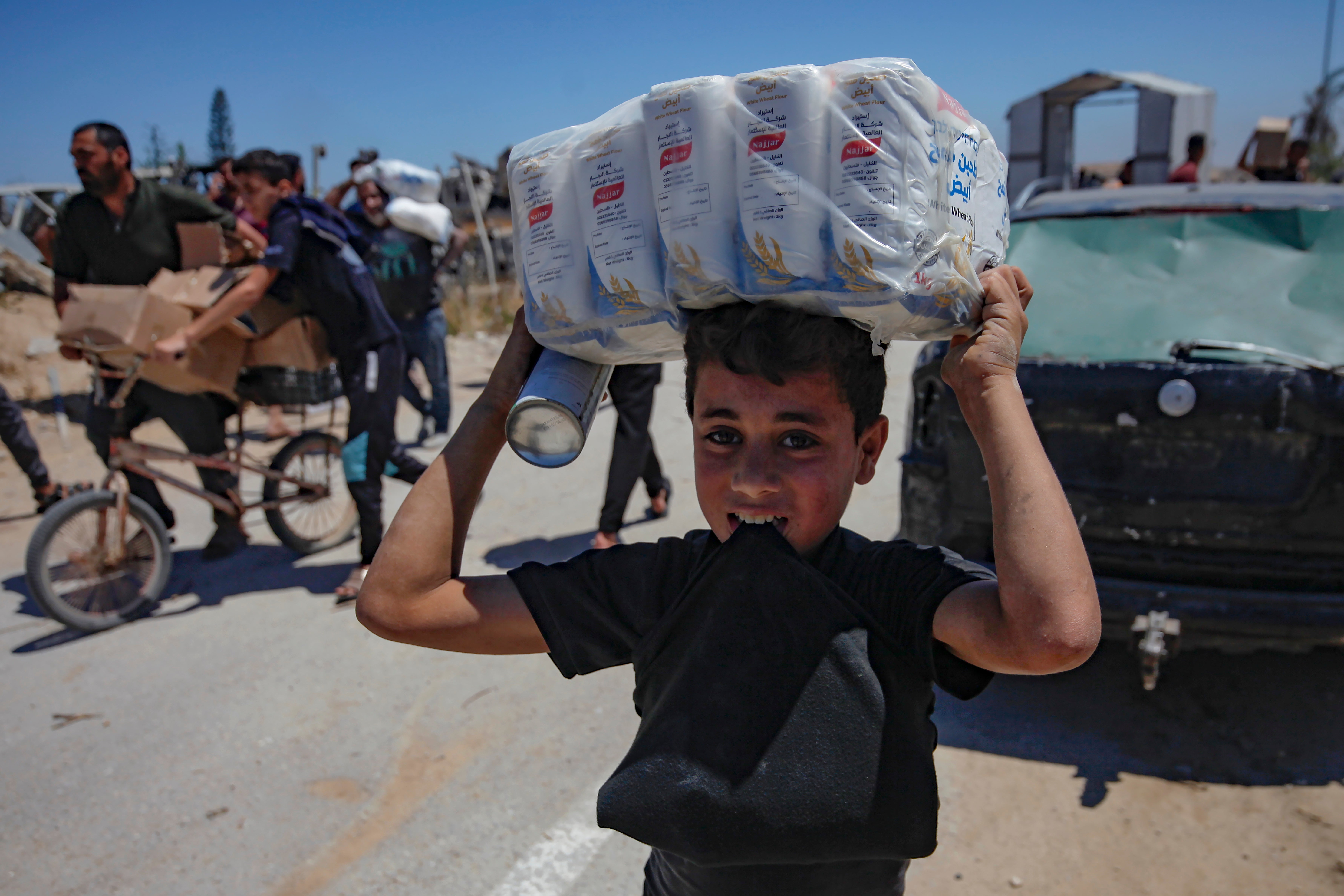A Palestinian child carries aid from a US-backed centre near the Netzarim Corridor