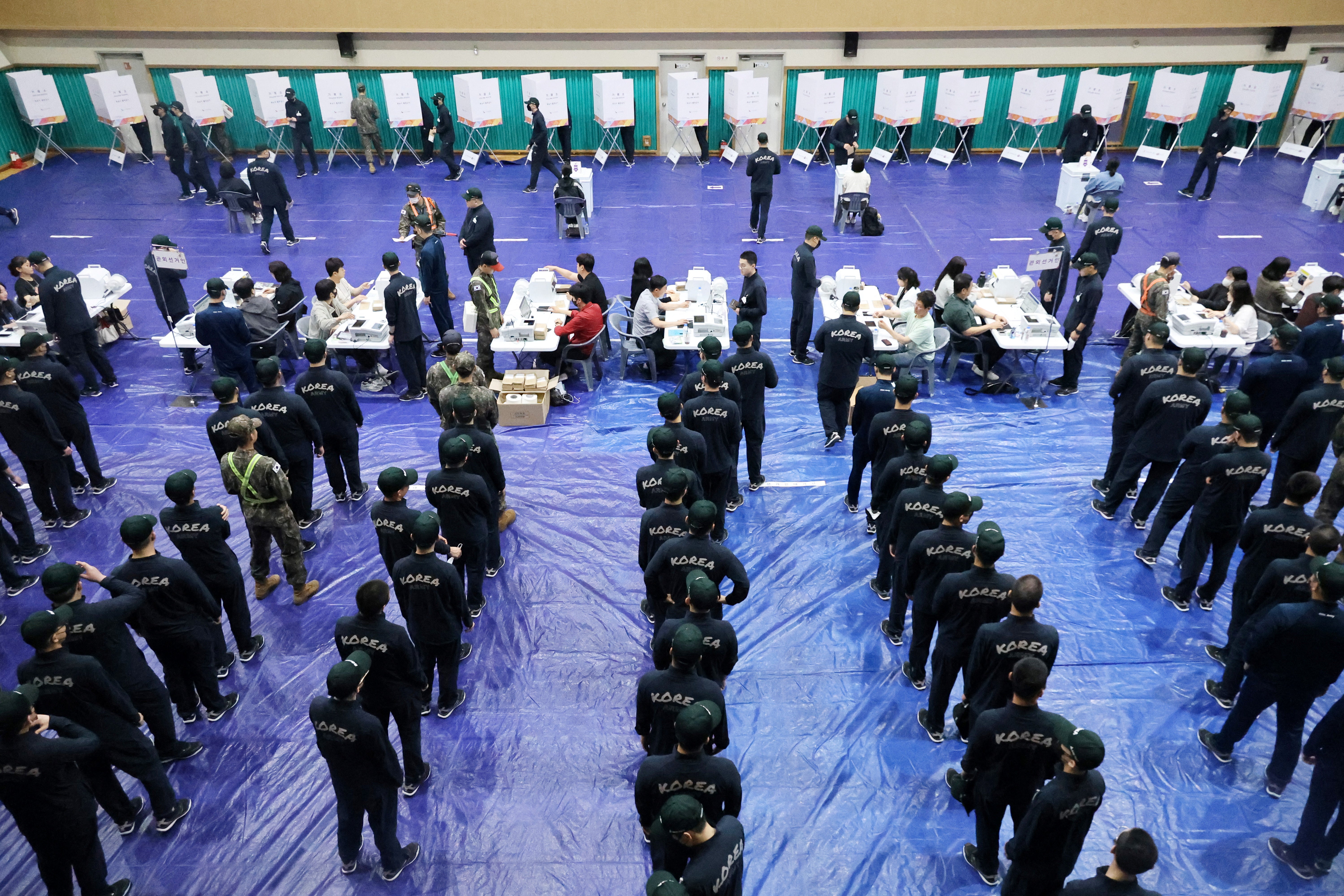 South Korean soldiers wait in a line to cast their early vote for the upcoming presidential election at a polling station in Nonsaan