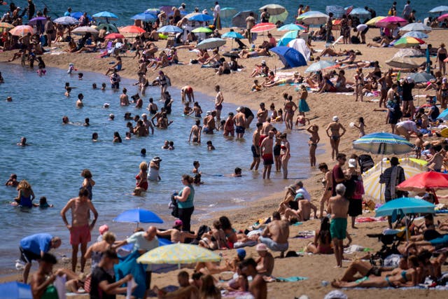 <p>Bathers cool off in the water while others sunbathe on a Barcelona beach, Spain, Wednesday, July 24, 2024</p>