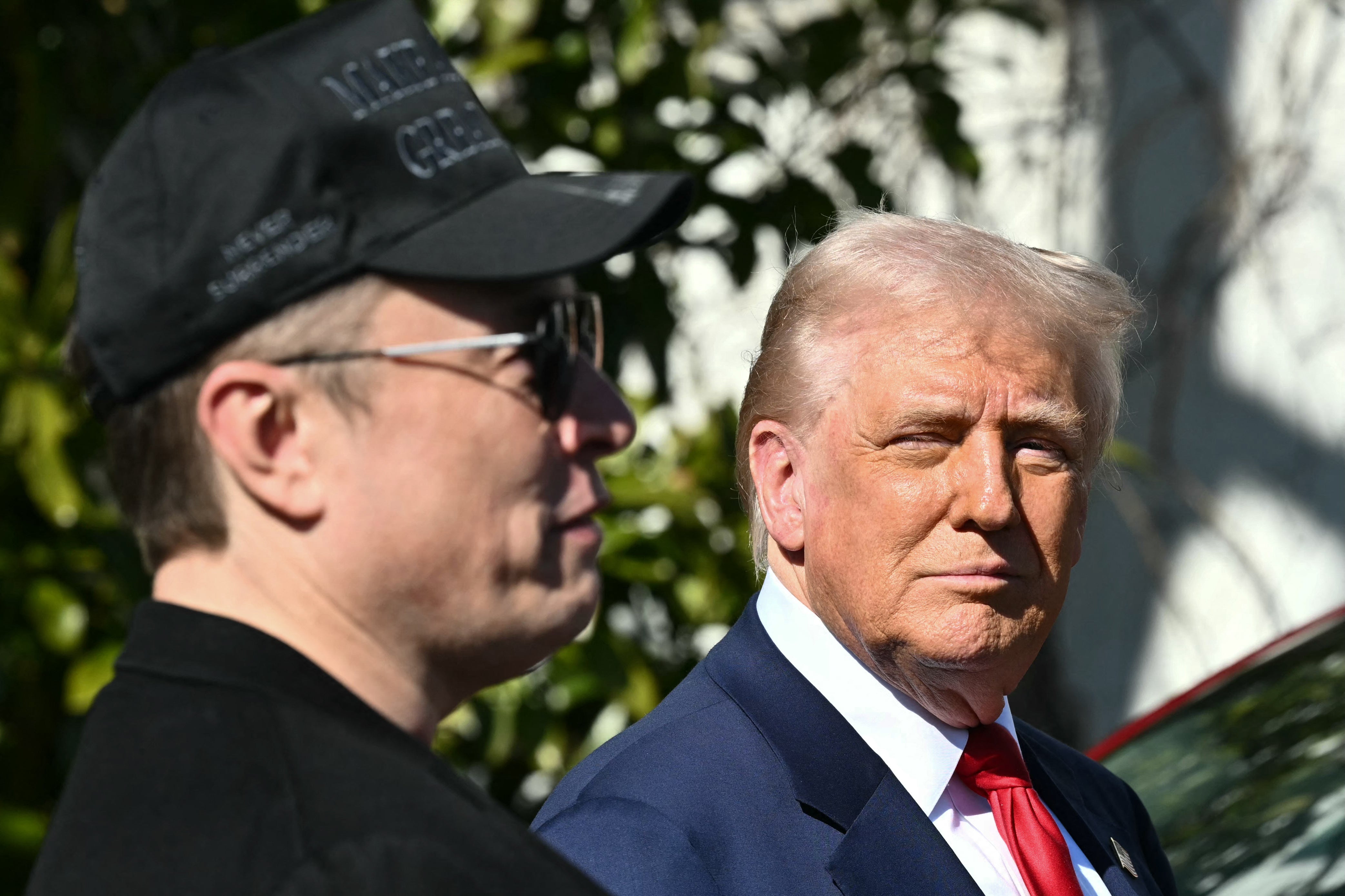 US President Donald Trump and Tesla CEO Elon Musk speak to the press as they stand next to a Tesla vehicle on the South Portico of the White House in March