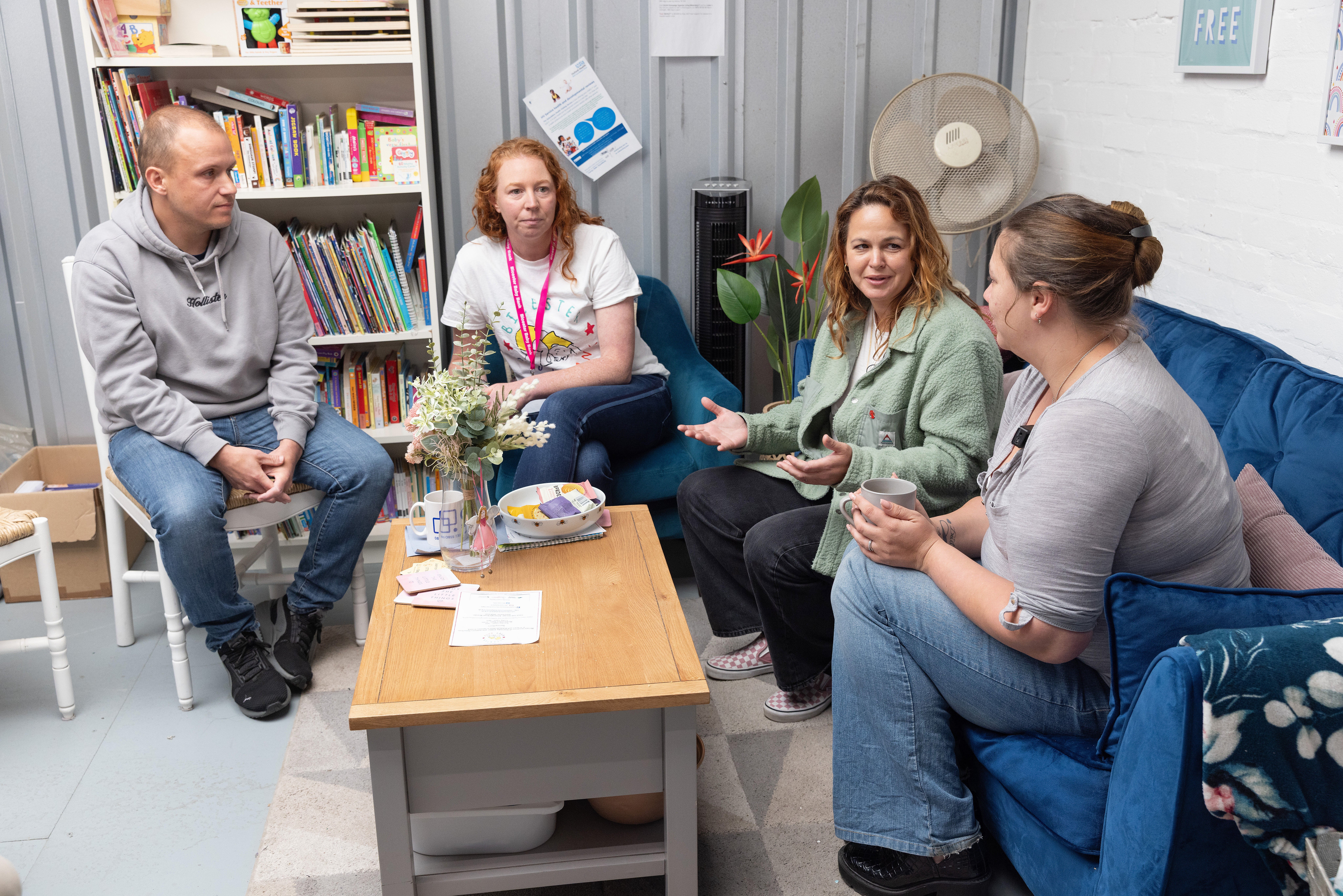 Parents including Adam Coggins (left) and Kirsty-Louise Fulford (right) speak with Giovanna Fletcher (second from right) at Bicester Baby Bank