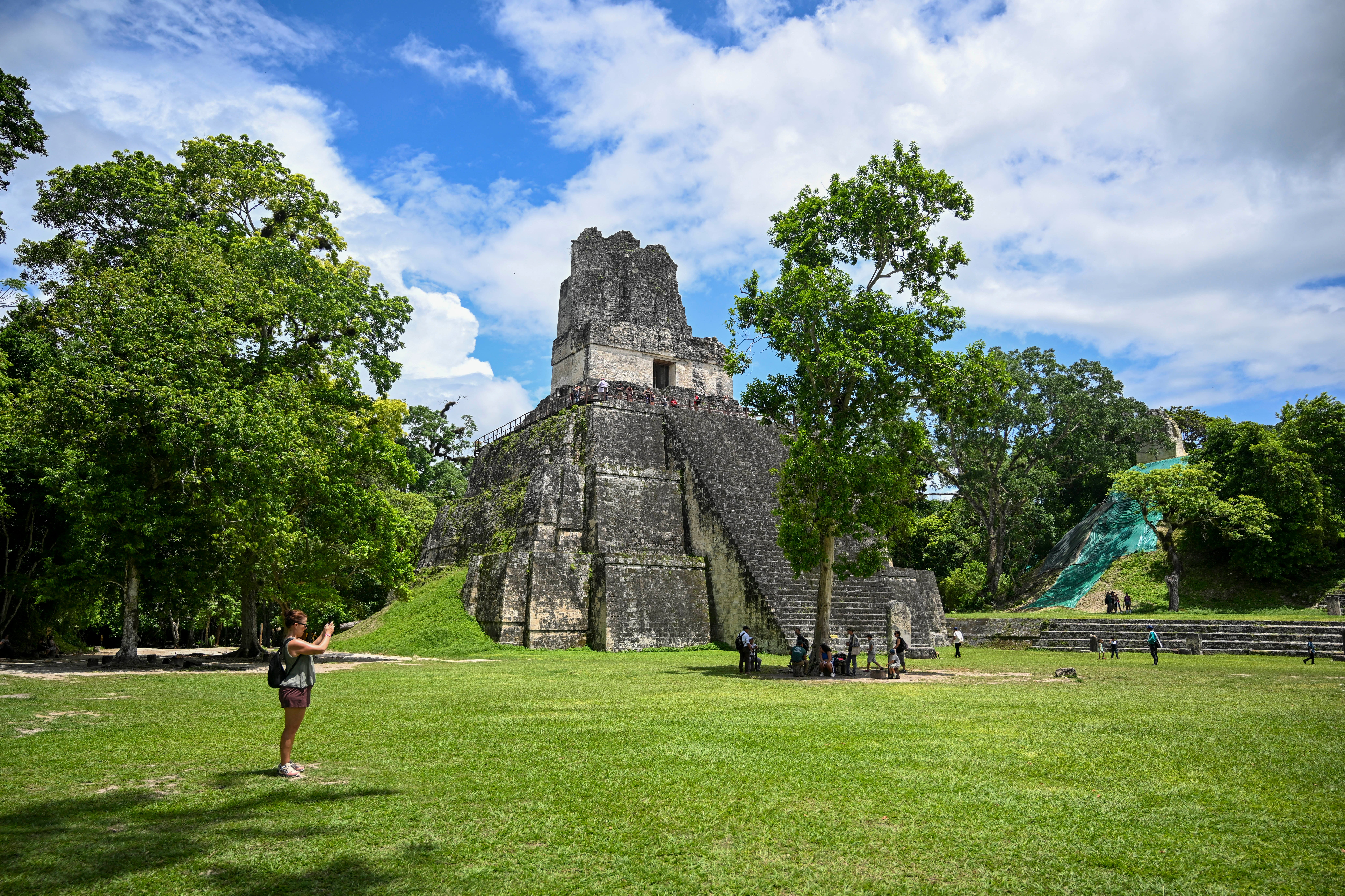 A tourist takes pictures in front a Mayan temple in the Tikal archaeological site in Peten