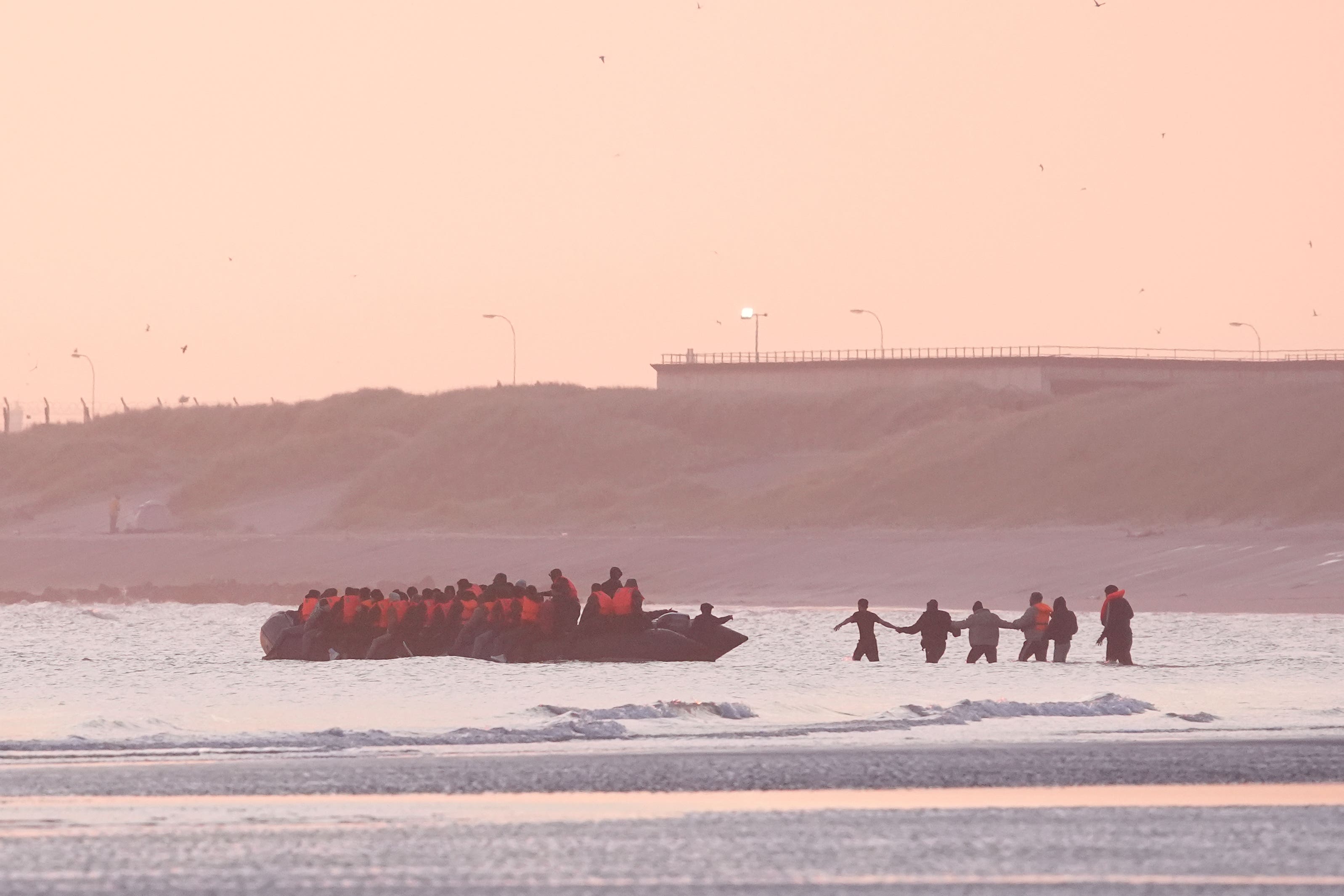 People thought to be migrants board a small boat leave the beach at Gravelines, France
