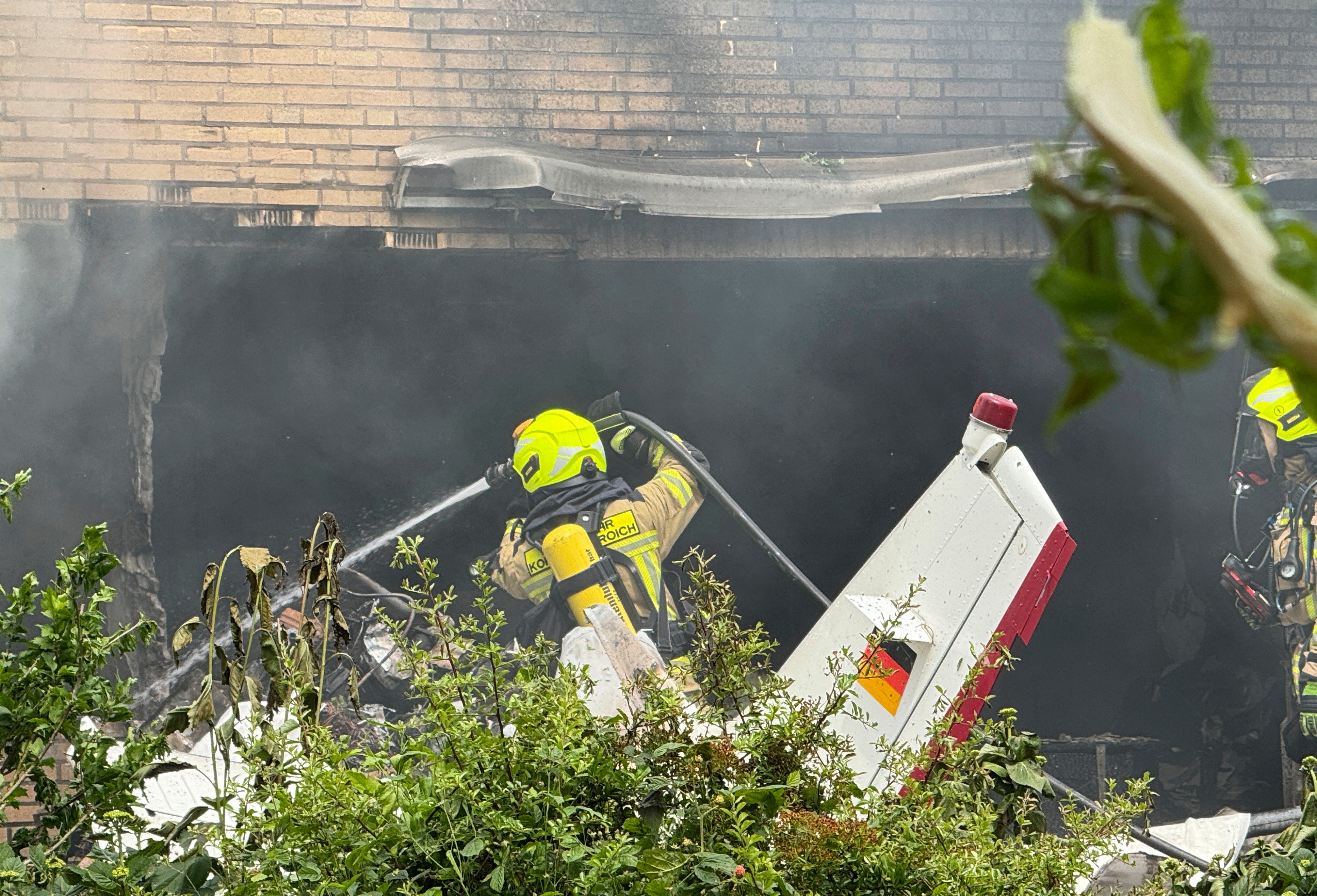 Firefighters work at the crash site after an airplane crashed into a residential building, in Korschenbroich, Germany, Saturday, May 31, 2025.