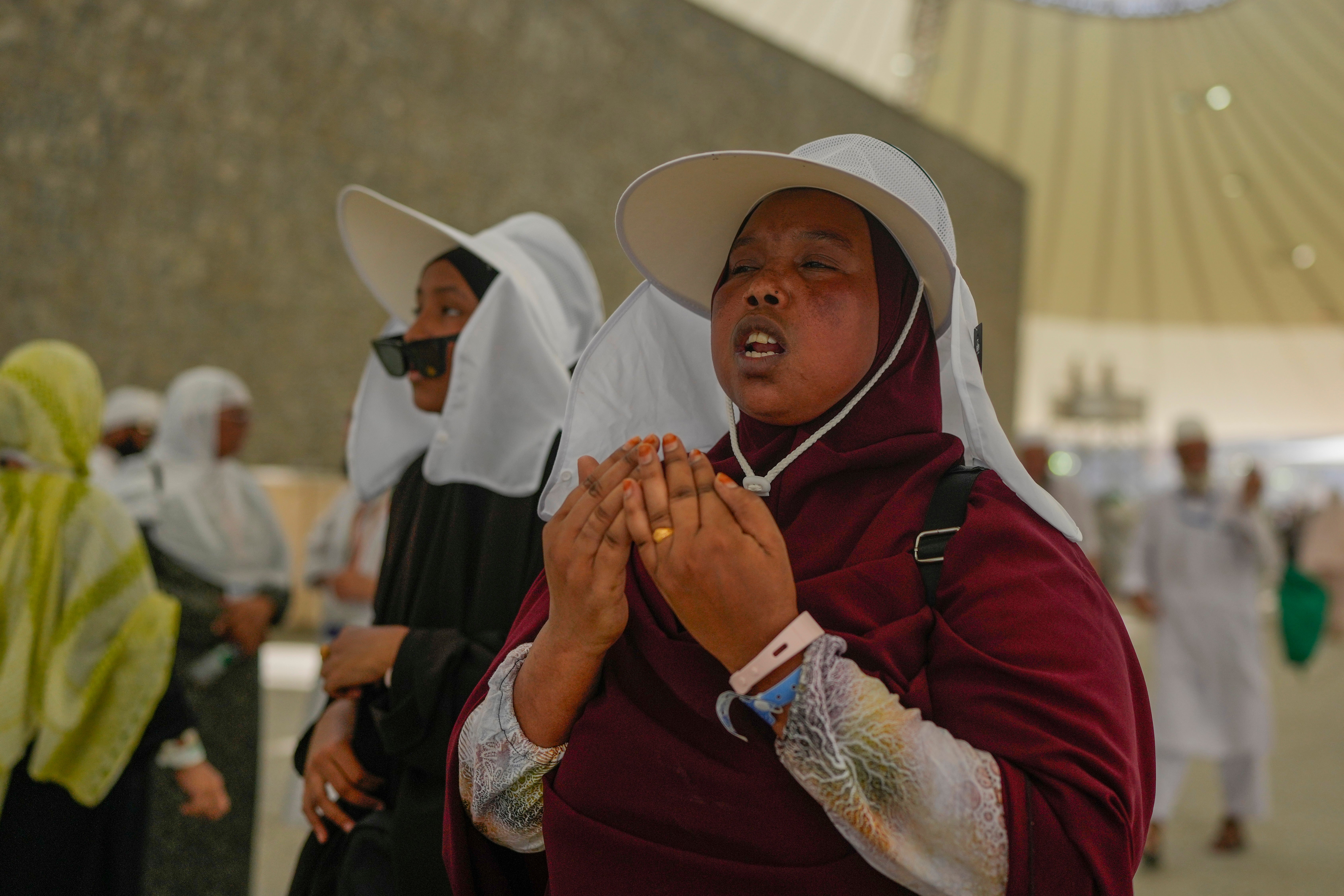 A pilgrim offer prayers after she cast stones at a pillar in the symbolic stoning of the devil, during the annual Hajj pilgrimage in Mina, near the holy city of Mecca, Saudi Arabia, Tuesday, June 18, 2024