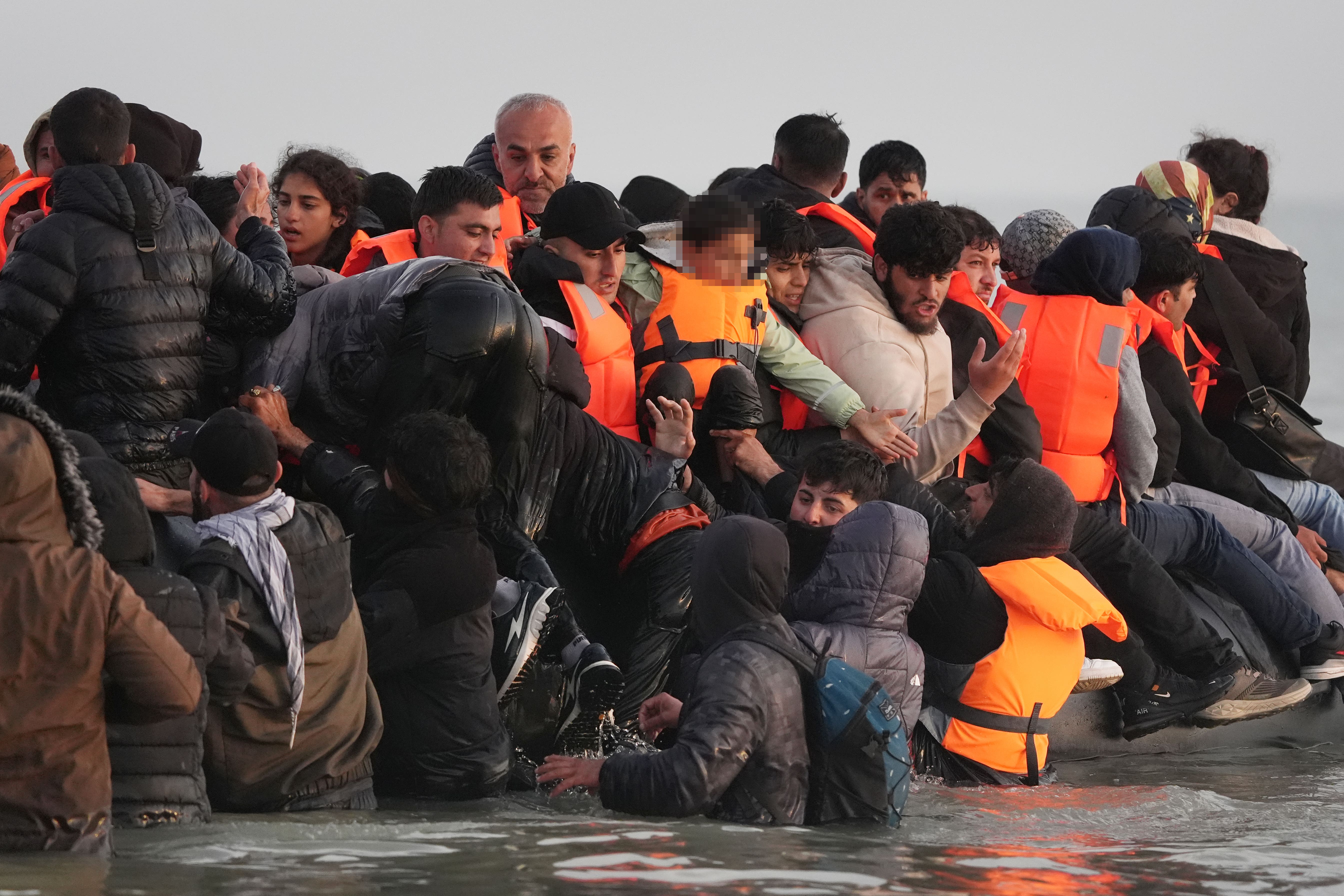 People thought to be migrants scramble on board a small boat leaving the beach at Gravelines, France, on Saturday (Gareth Fuller/PA)