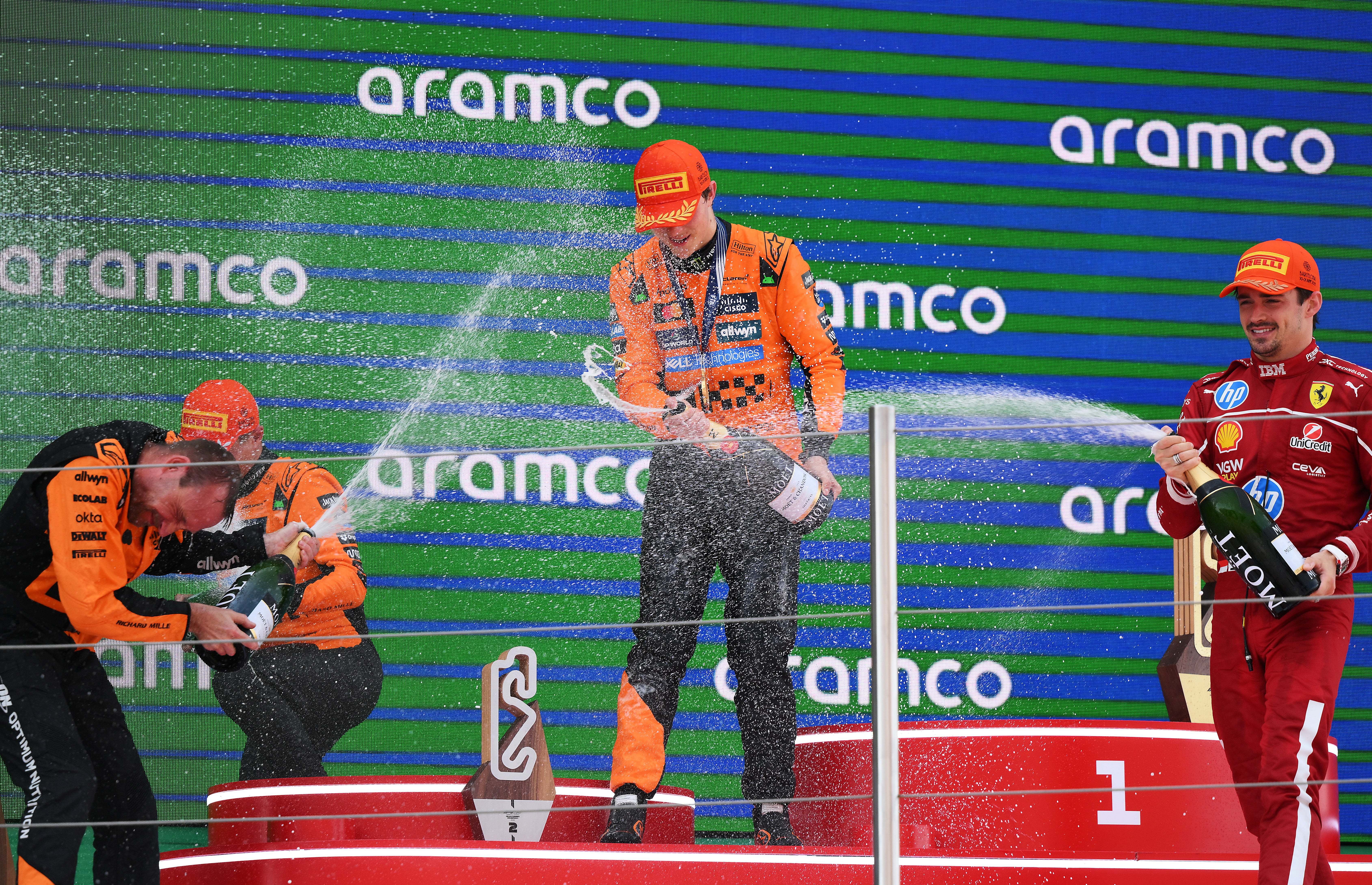 Charles Leclerc, right, sprays his McLaren rivals on the podium
