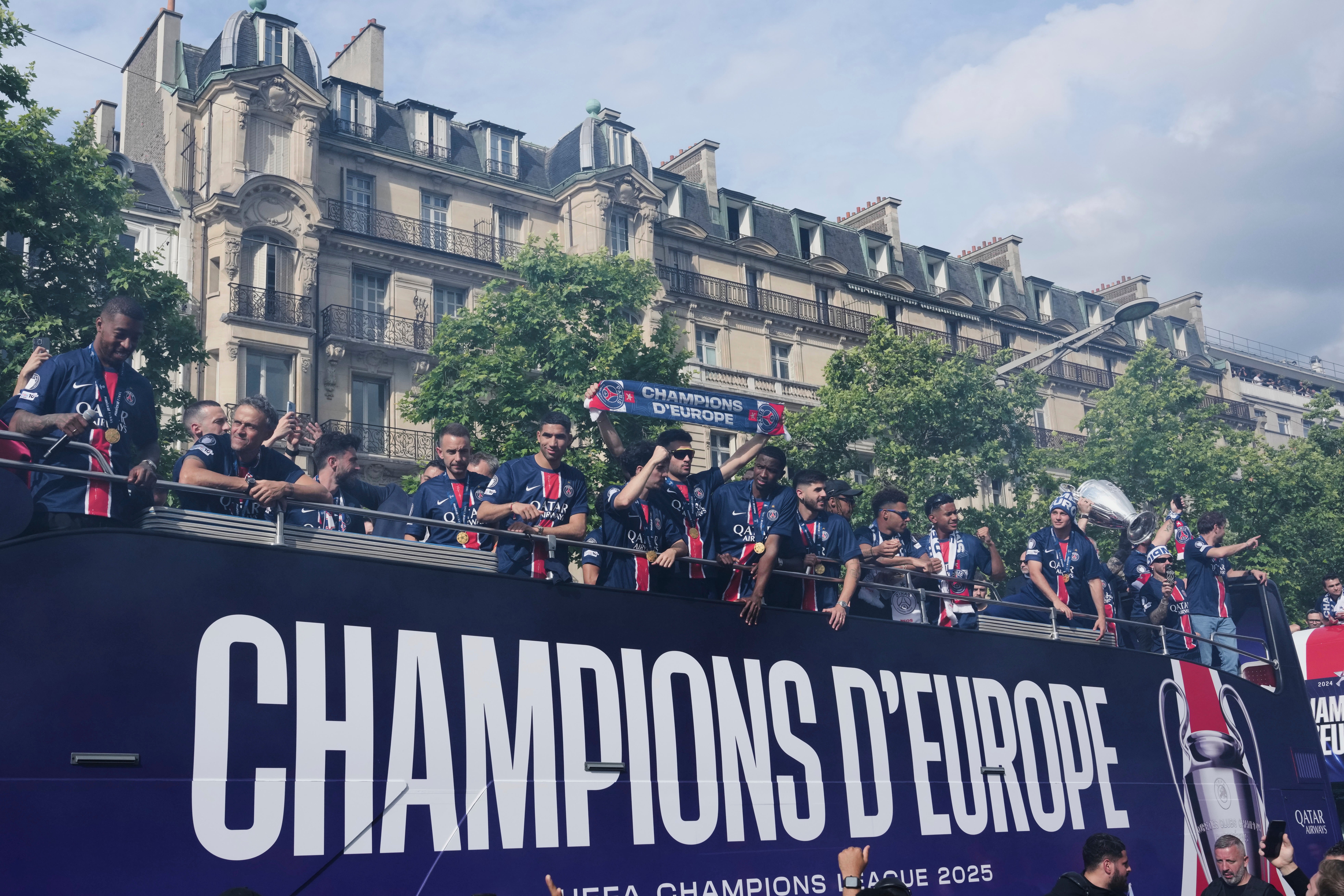 Paris St Germain players presented the Champions League trophy to supporters during a parade on the Champs Elysees (Aurelien Morissard/AP)
