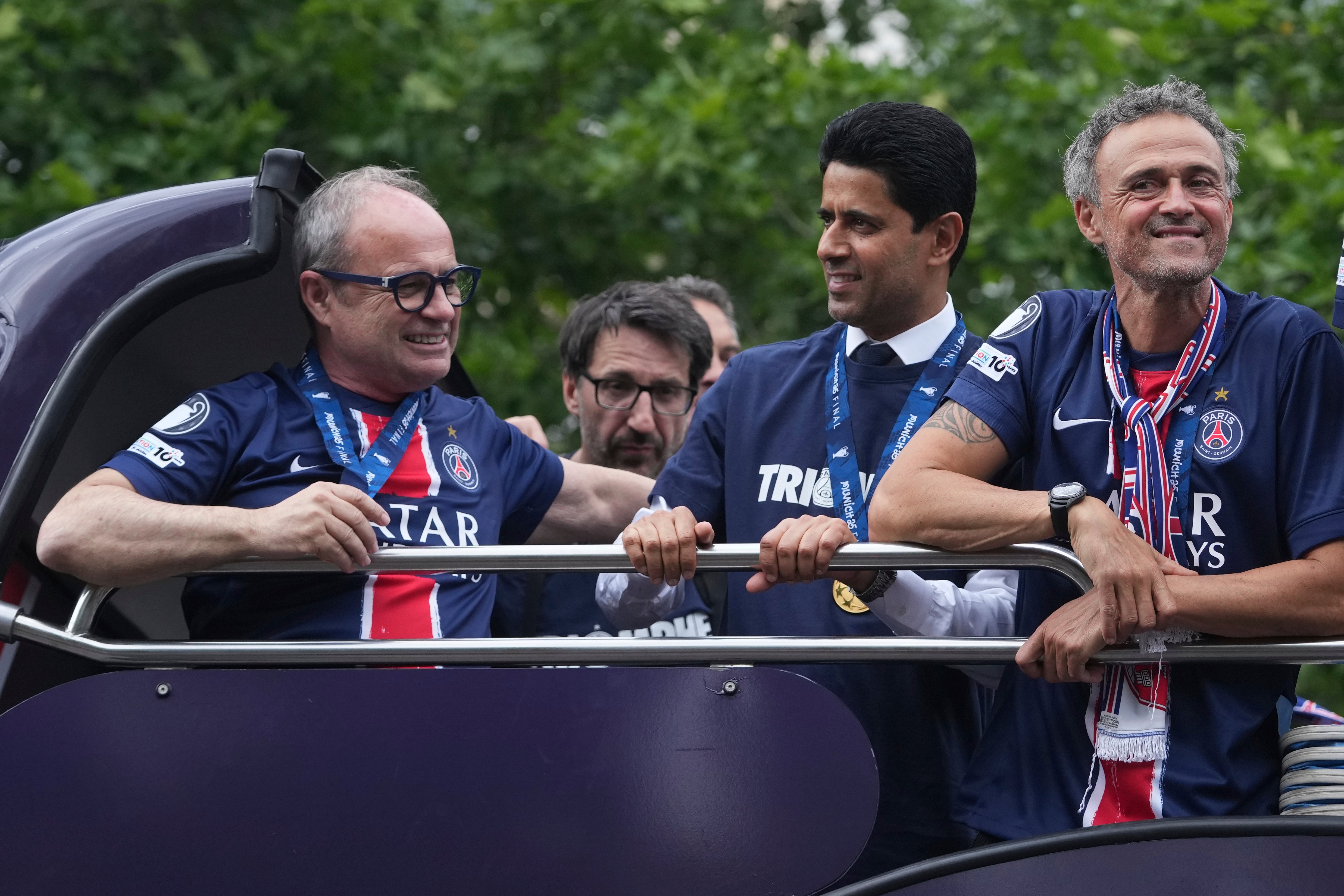 PSG head coach Luis Enrique, right, and club president Al-Khelaifi, centre, enjoyed the trophy parade (Thibault Camus/AP)