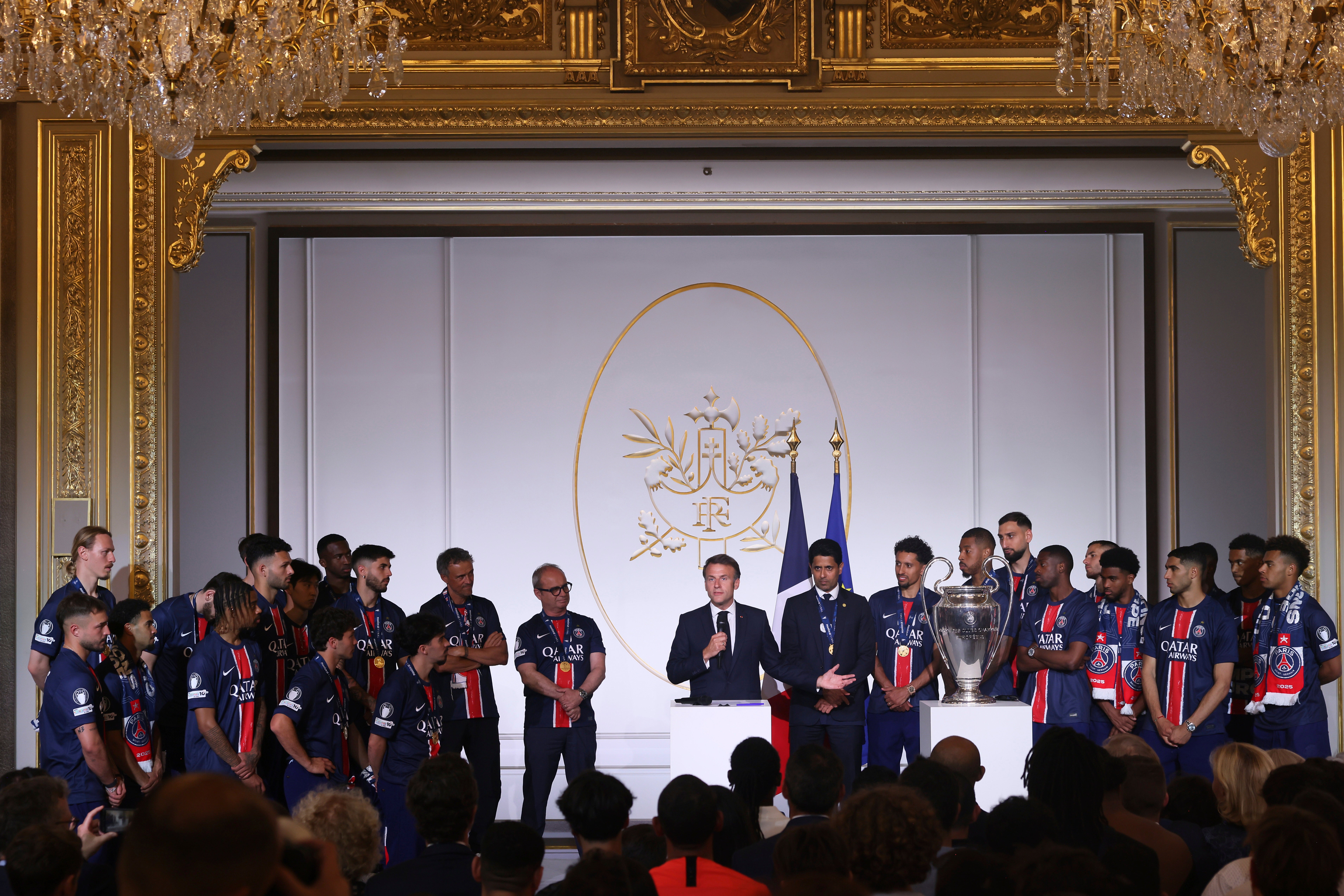 French President Emmanuel Macron (centre) congratulates Paris St Germain players at the Elysee Palace after the team won the Champions League (Thomas Padilla/PA))
