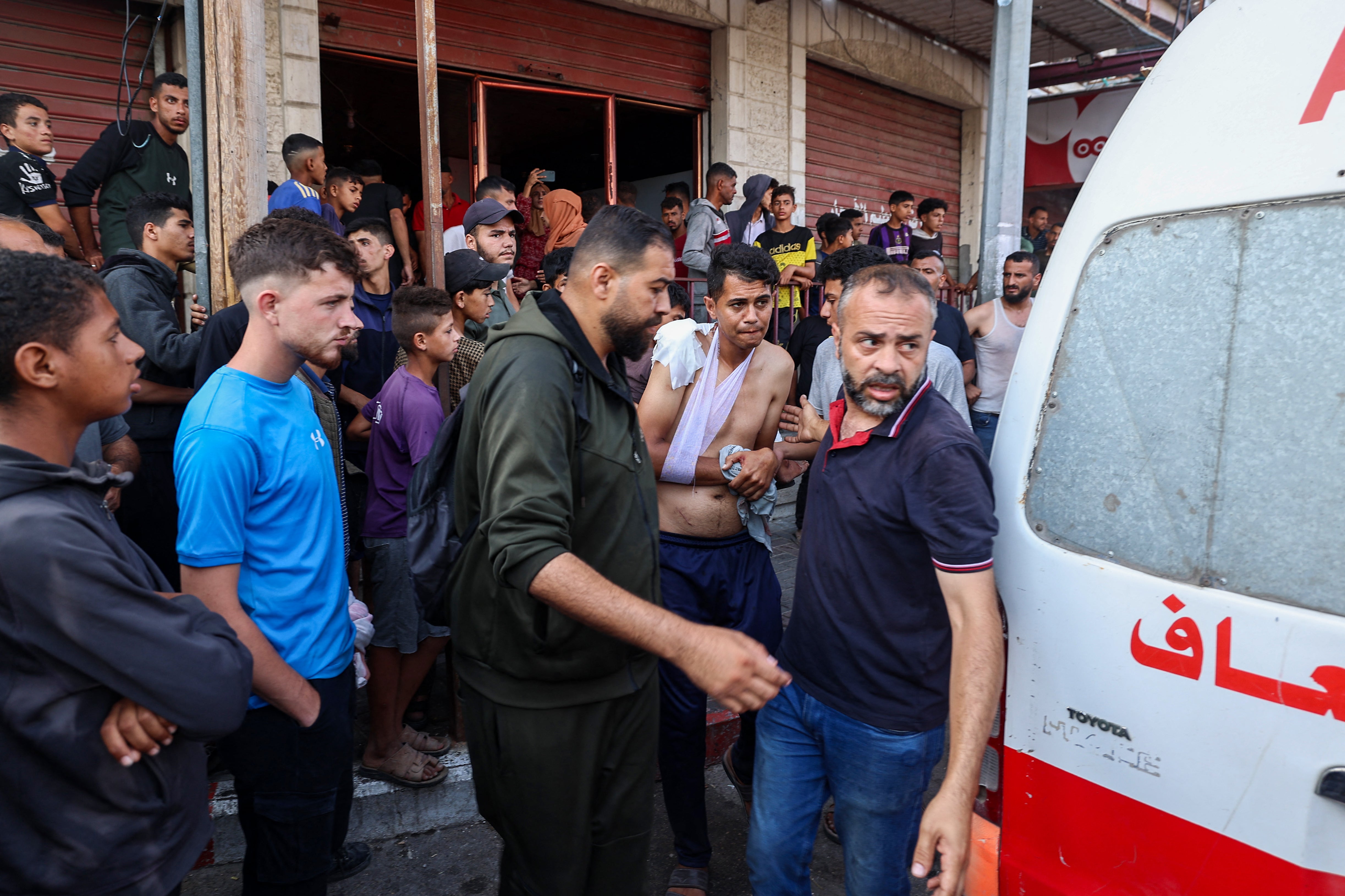 Palestinians injured by a drone strike on their way to a food distribution centre are taken to hospital on Sunday