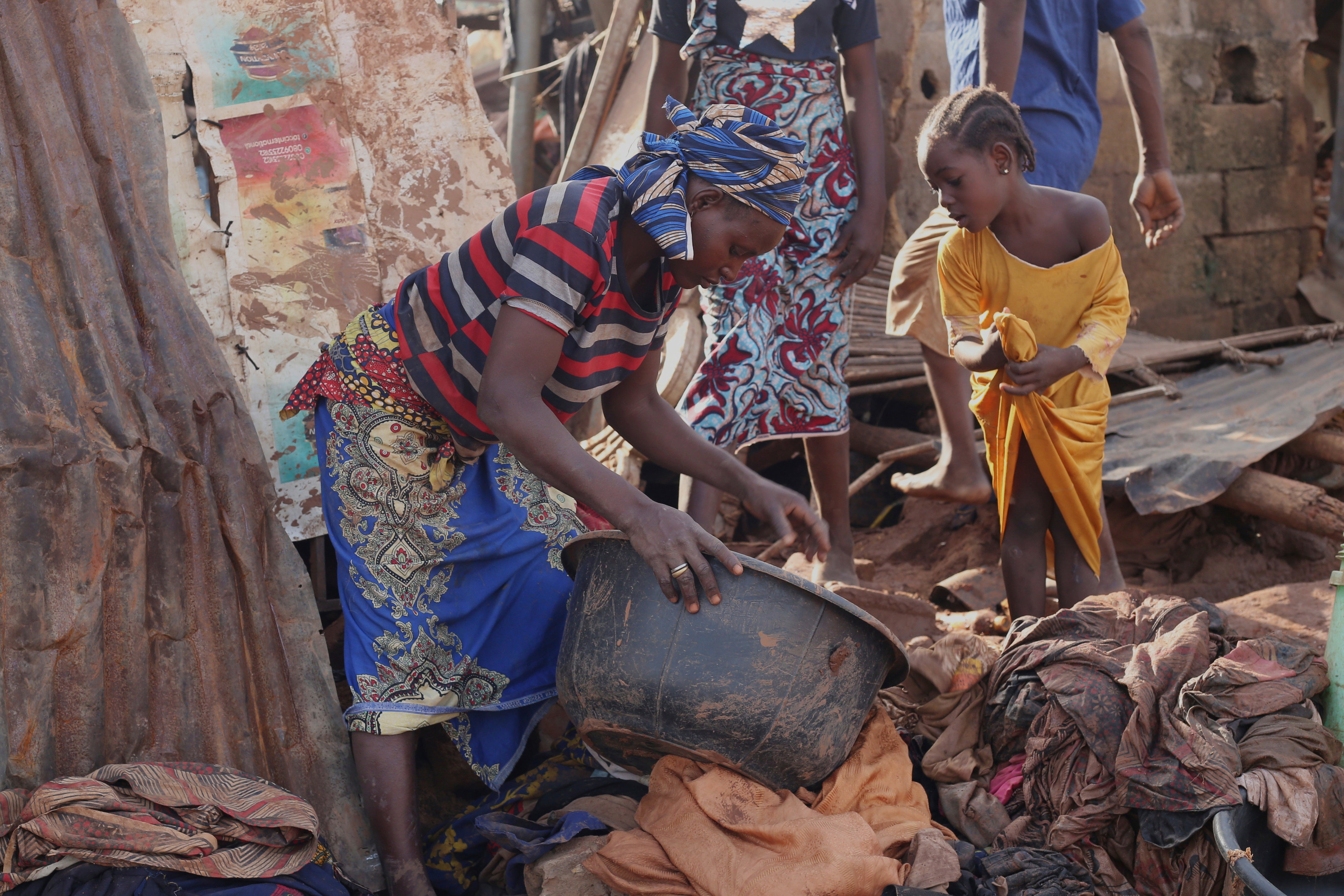 People salvage their belongings in a flooded area after heavy rainfall in the market town of Mokwa