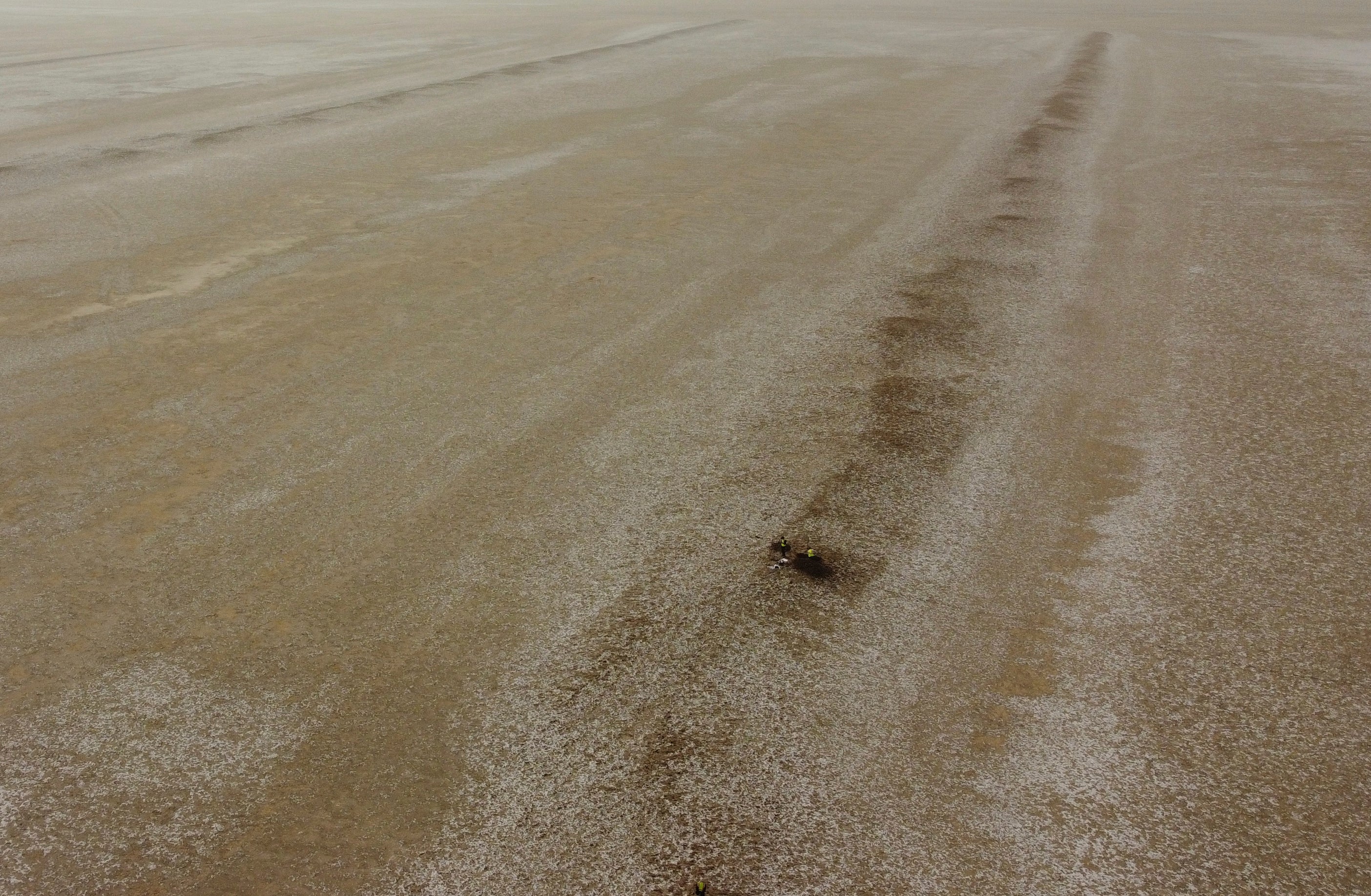An aerial photo shows archaeologists working at an archaeological site where researchers uncovered massive earthen structures, believed to have been built with slave labor, and found that their construction spanned several centuries, near Basra, Iraq, Friday, Jan. 28, 2022. (AP Photo/Jaafar Jotheri)