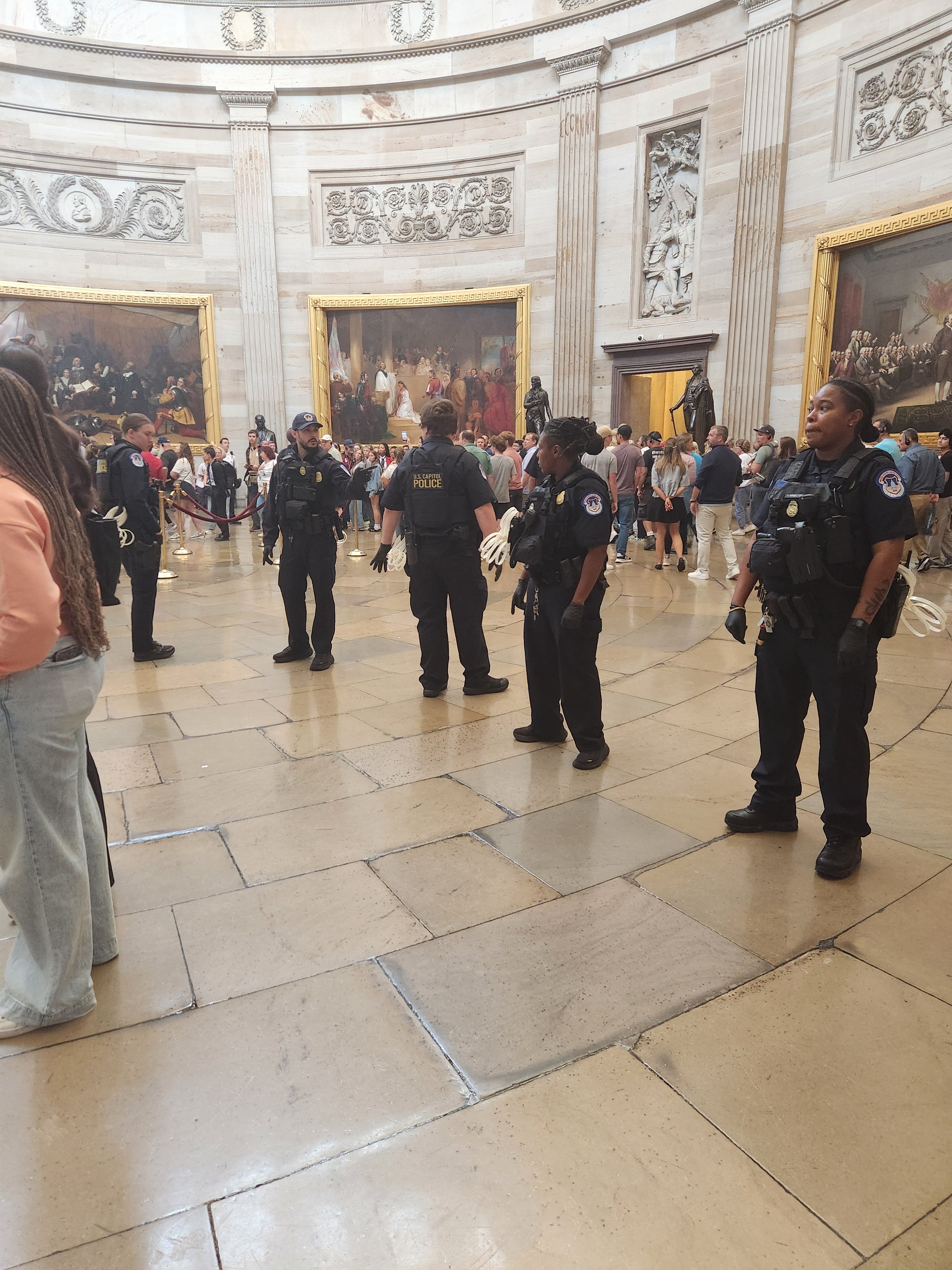 Capitol Police officers with zip-tie handcuffs prepare to arrest a group of clergy Monday