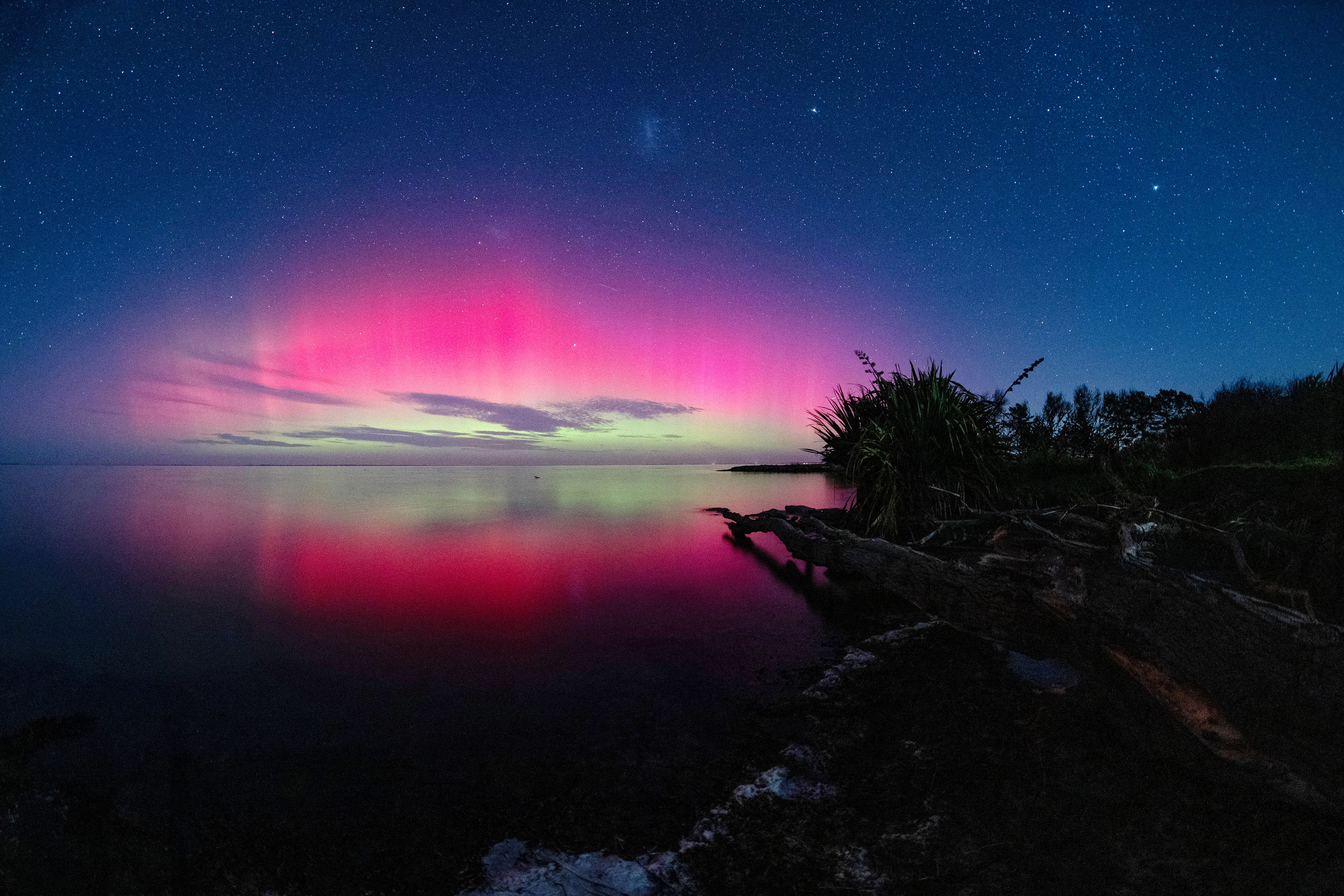 Southern lights glow over the waters of Lake Ellesmere on the outskirts of Christchurch, New Zealand